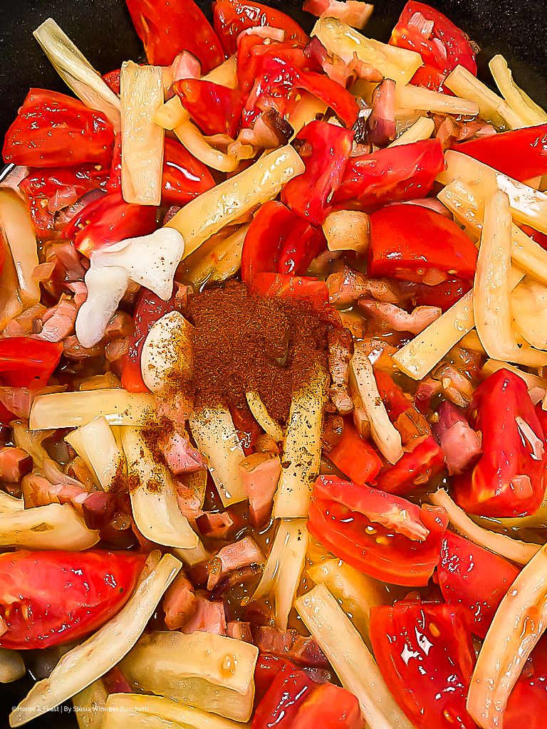 Fresh chopped tomatoes and onions mixed with herbs in a colorful salad preparation.