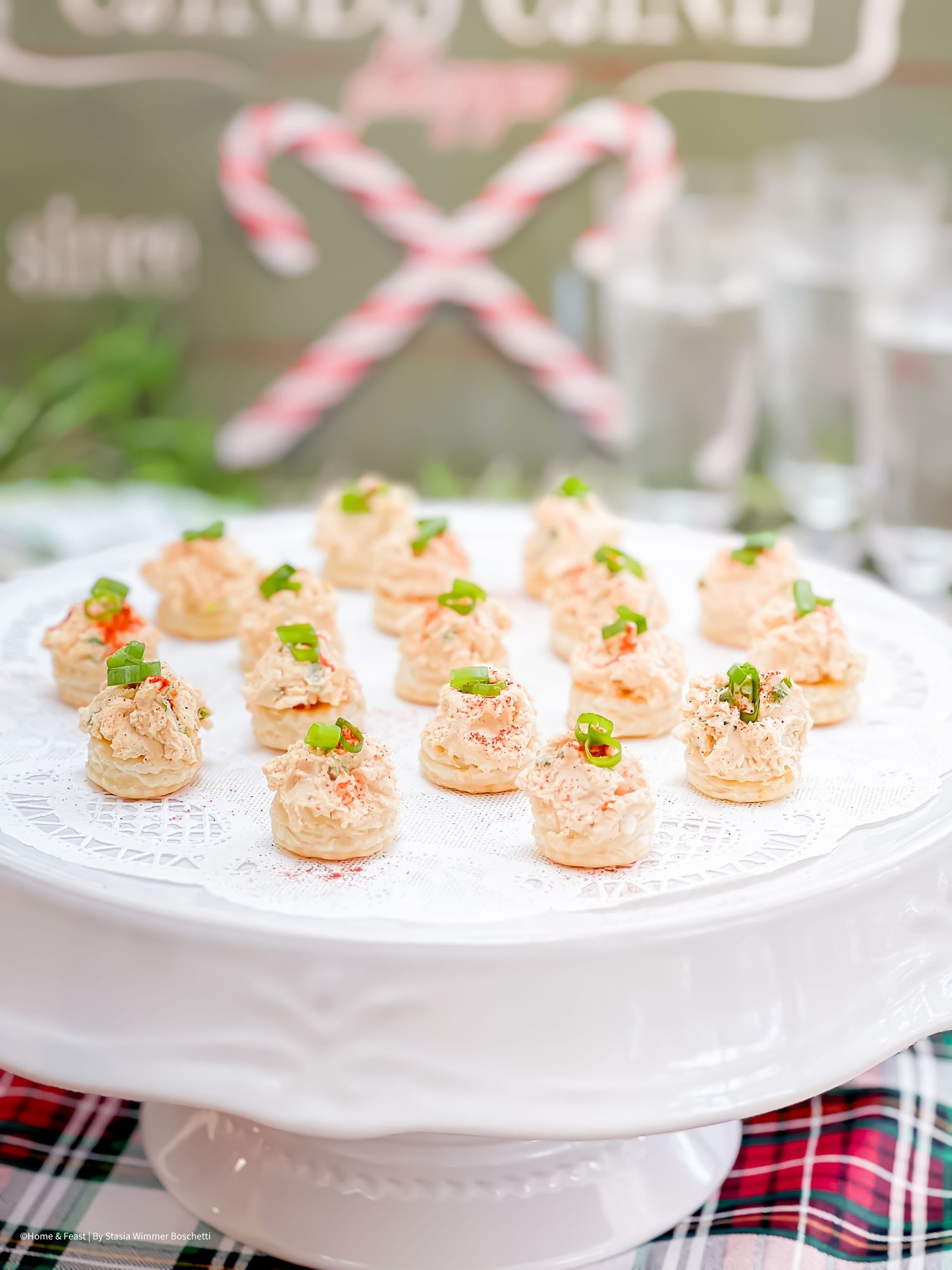 Delicate salmon-colored appetizers garnished with herbs served on a white pedestal plate.
