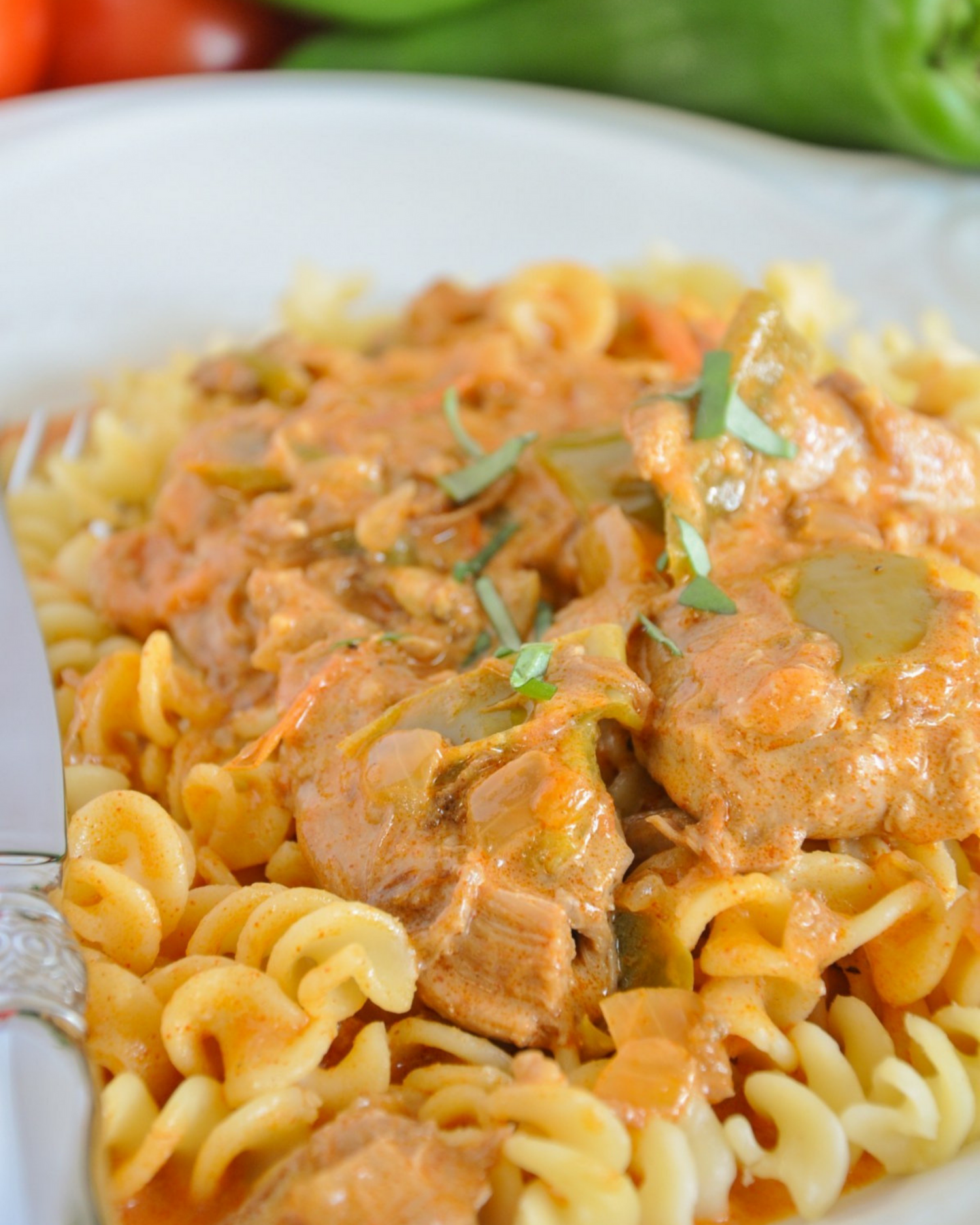 Creamy pasta with chunks of meat in a rich orange-colored sauce.
