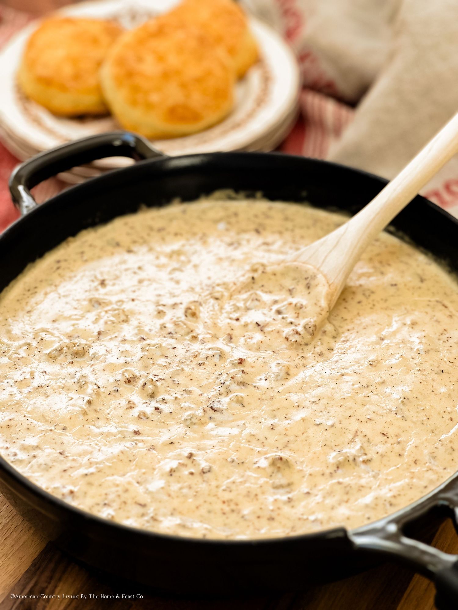 Thick country gravy with spices cooking in a black skillet.