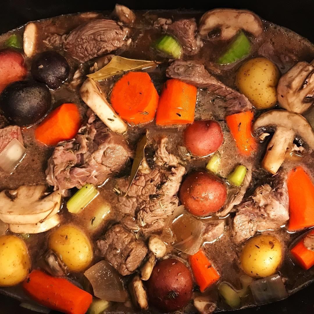 Tender beef pot roast simmering with carrots, mushrooms, potatoes and vegetables in a savory broth.