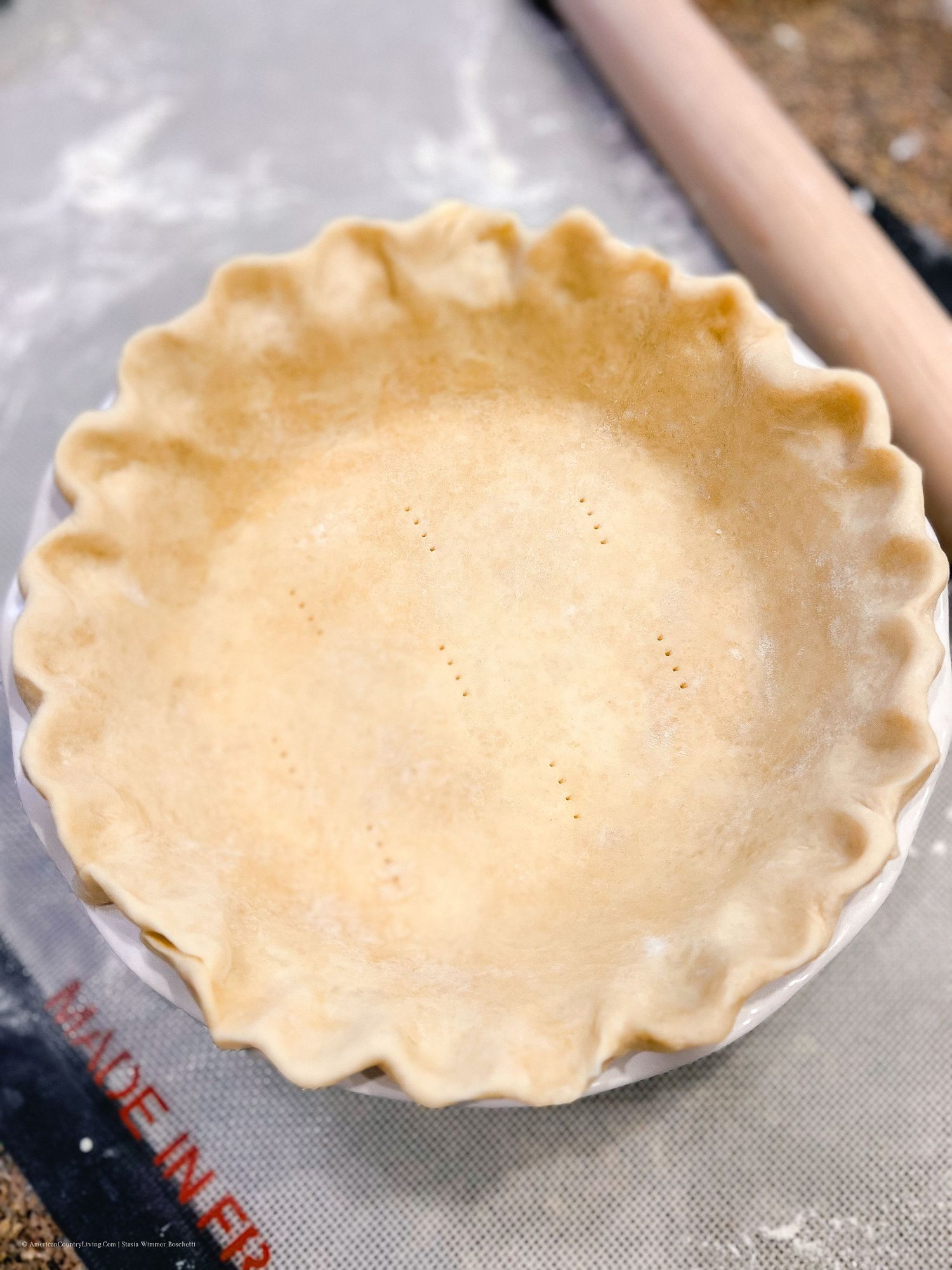 Empty pie crusts with crimped edges arranged in ceramic baking dishes.