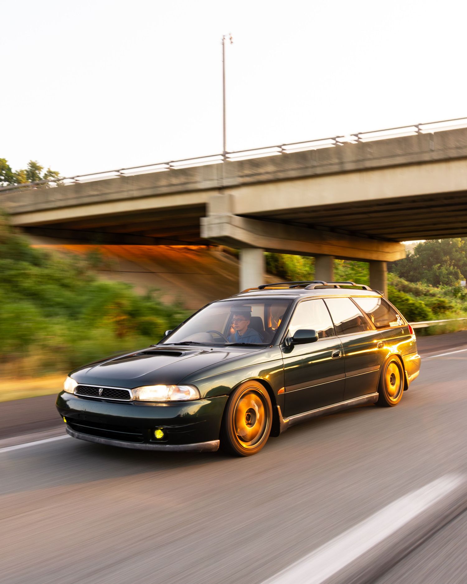 Green Subaru Legacy heading to Boxer Fest during sunrise