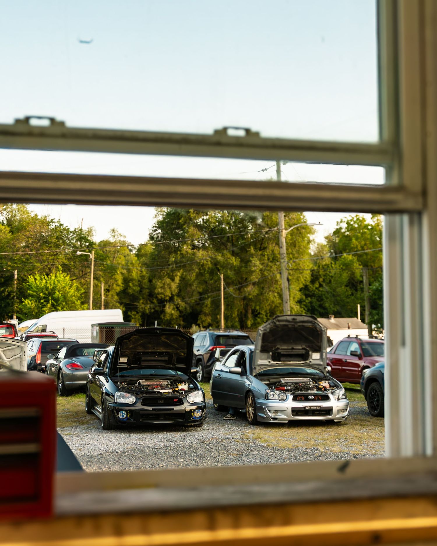 Subarus during sunset at a pre boxer fest hangout. shot through the shop window
