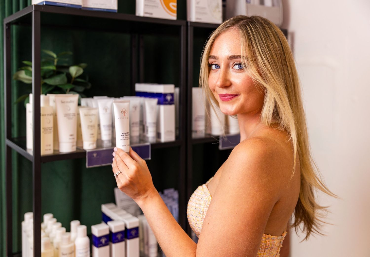 Beauty product display with organized skincare items on dark shelves.