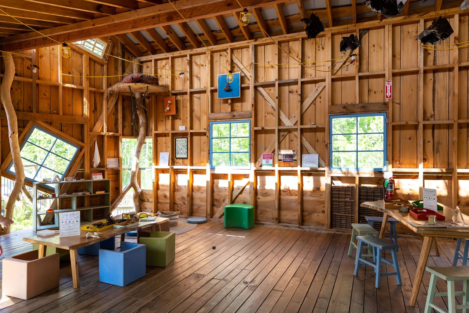 Rustic wooden barn interior with exposed beams, windows, and workshop storage space.