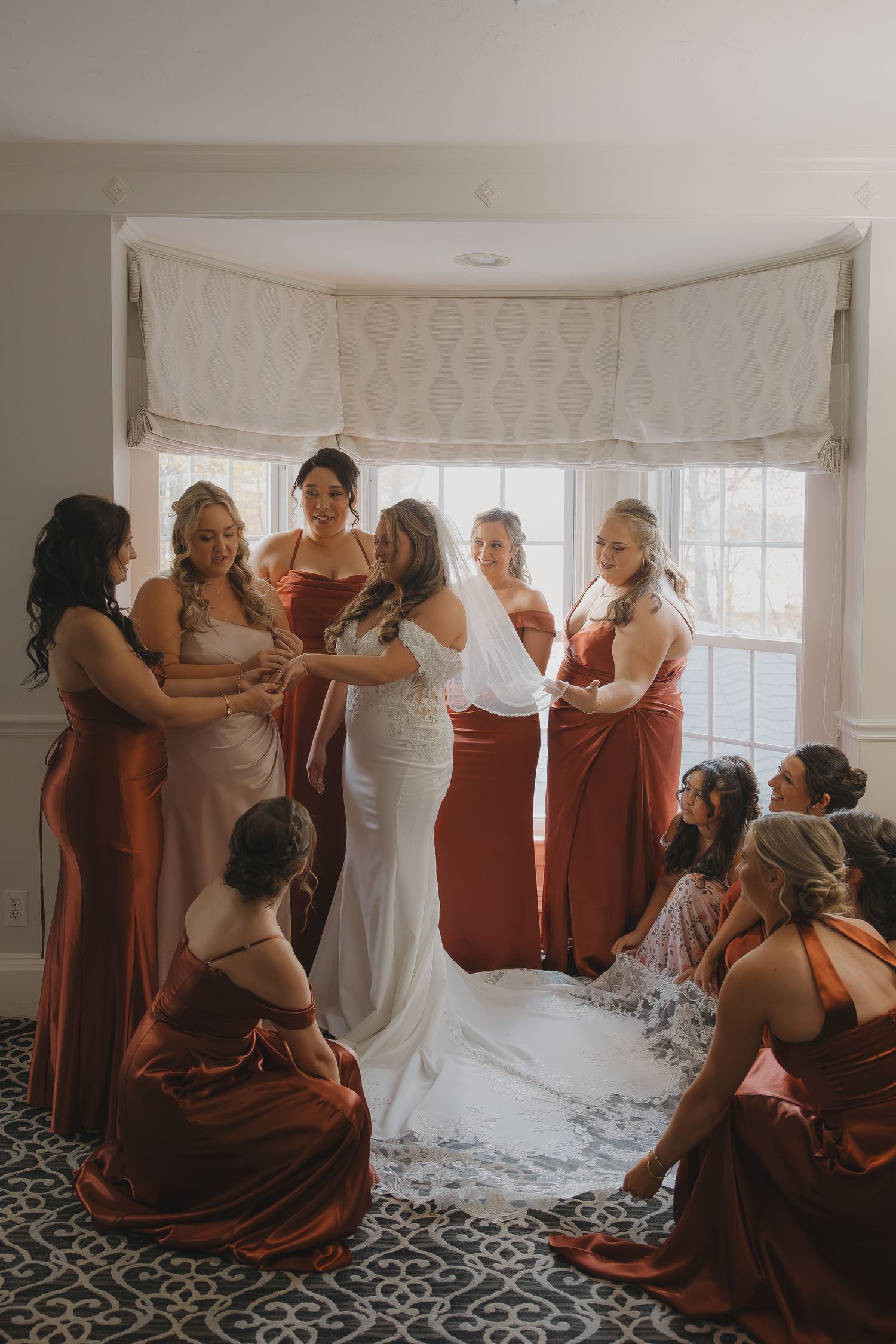 Bridesmaids laughing and getting ready together before a wedding at Saphire Estate in Massachusetts.