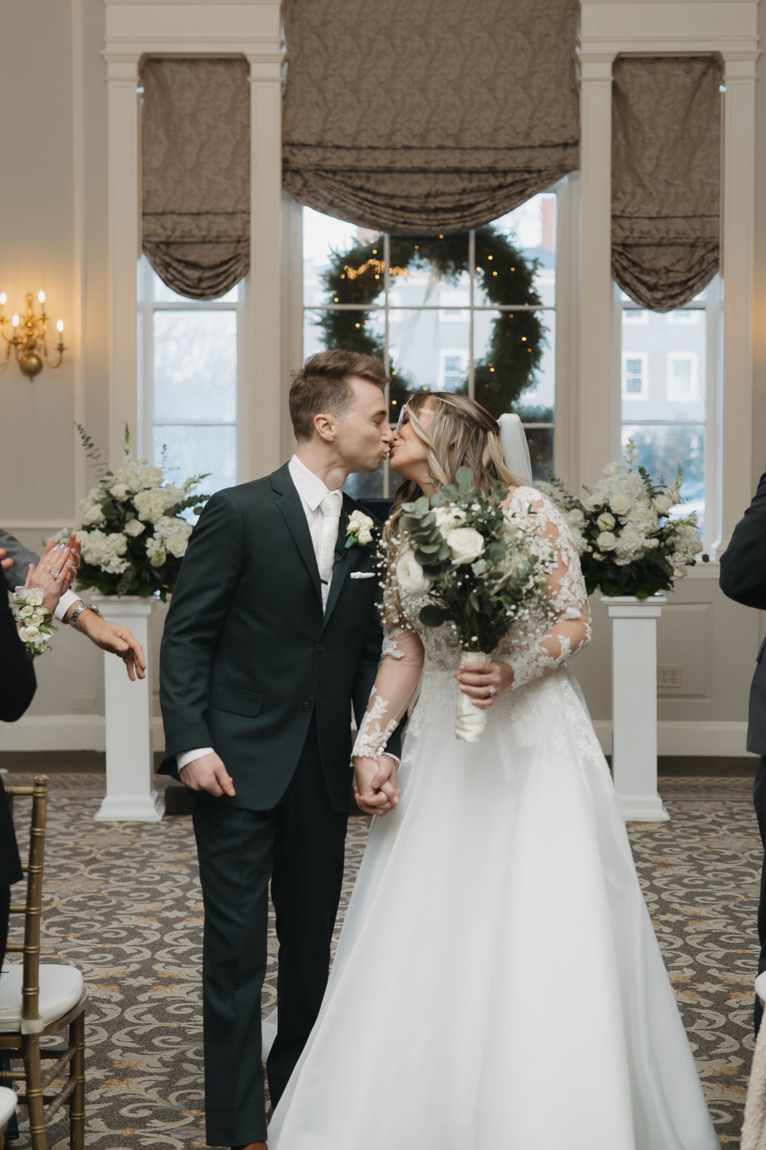 bride and groom kissing after wedding ceremony walking down the aisle