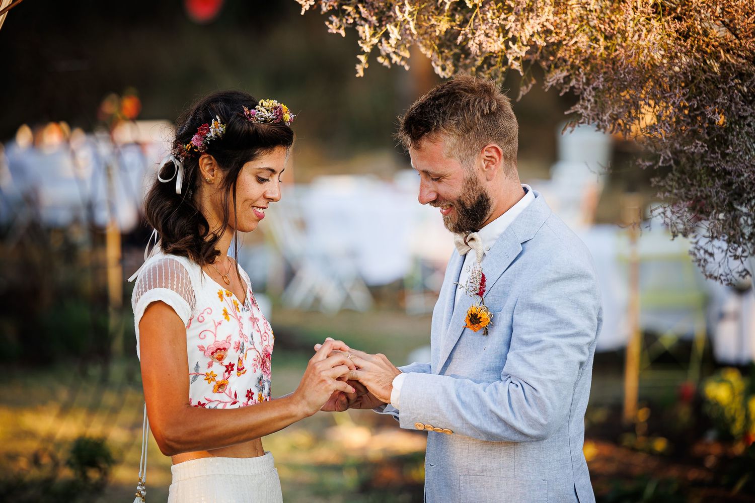 Couple exchanges rings during intimate outdoor ceremony.