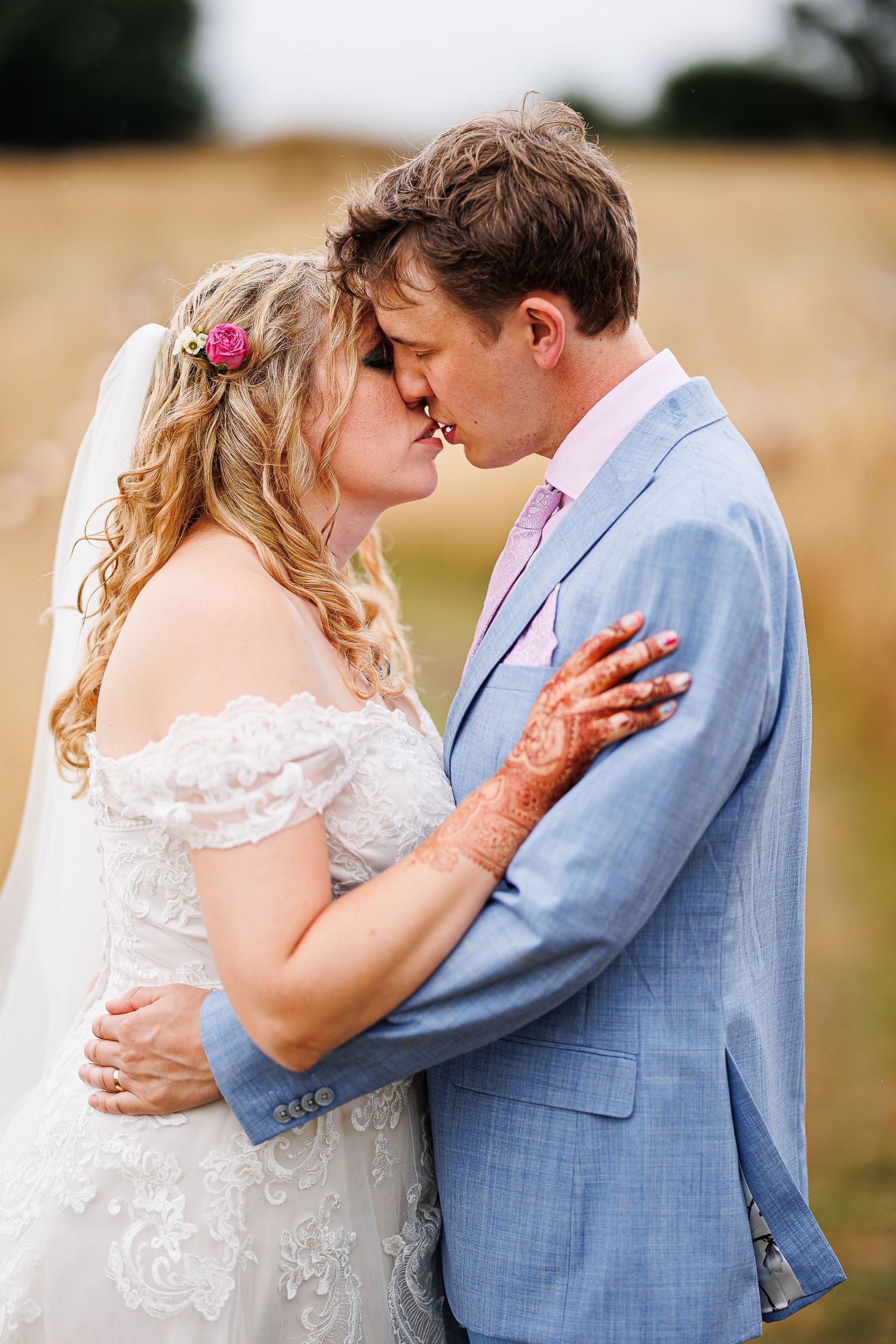 Romantic wedding portrait of a couple embracing in formal attire.