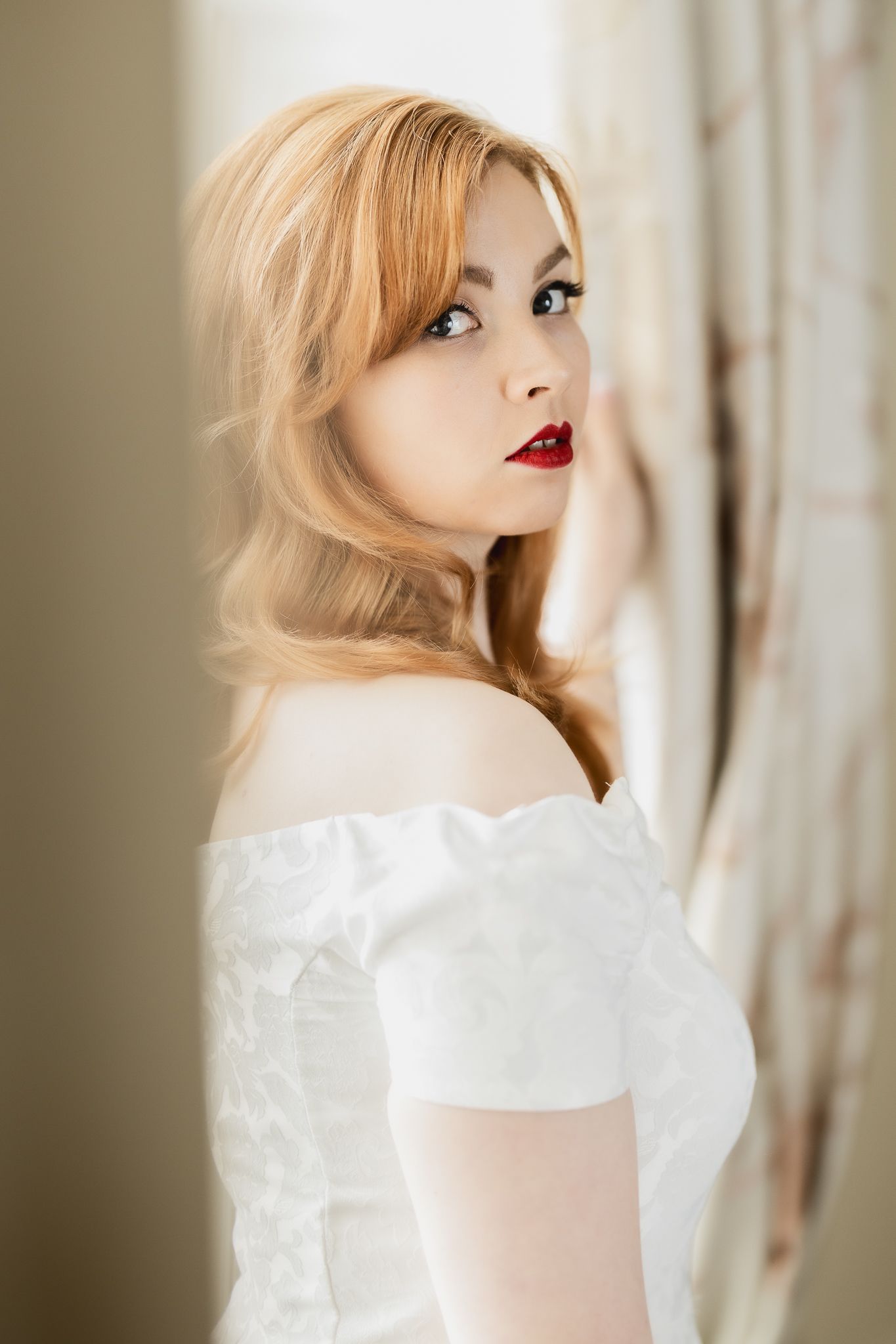 Classic bridal portrait featuring off-shoulder white gown and vintage styling.