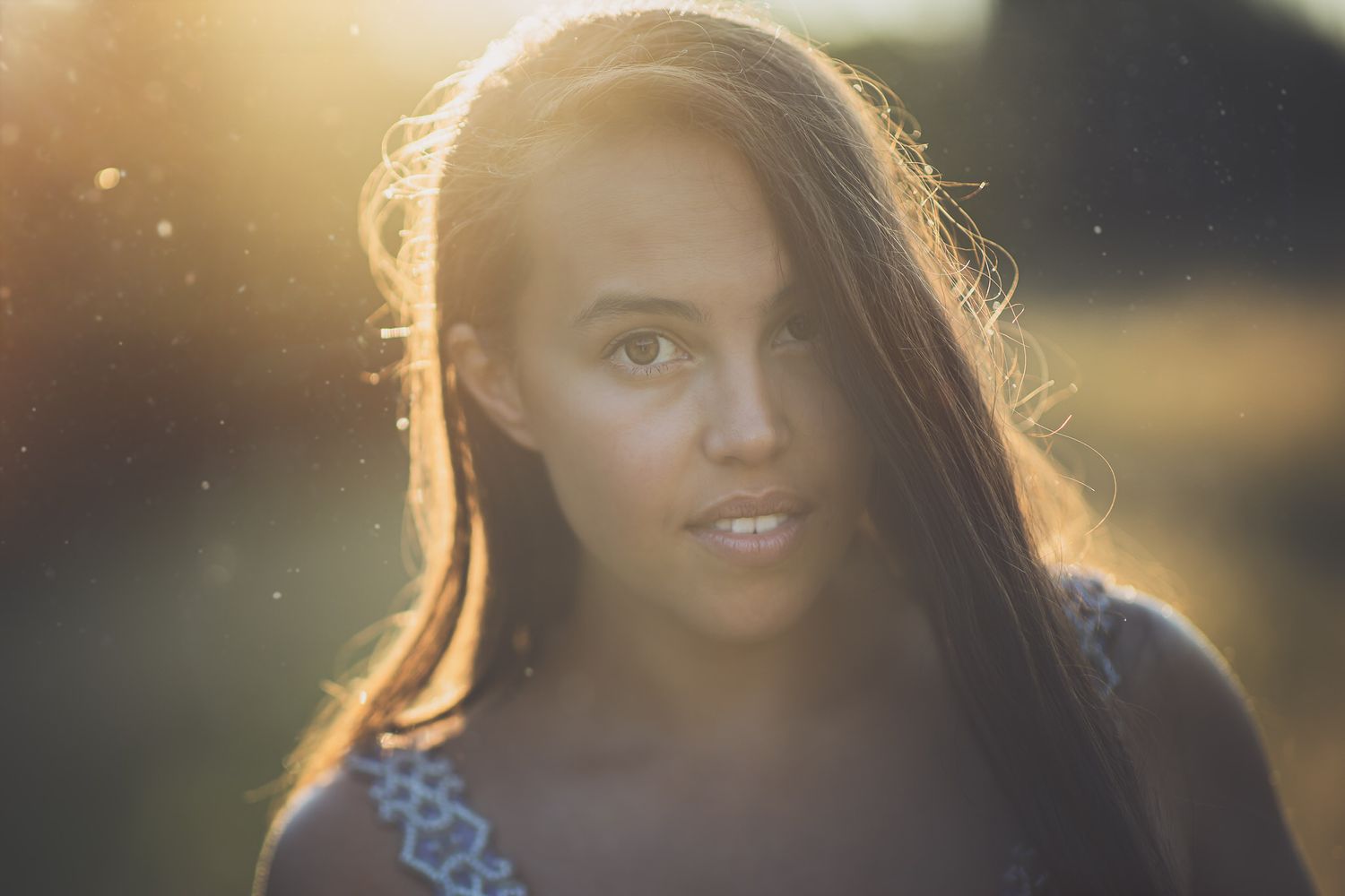 Portrait of a woman backlit by golden sunlight with a dreamy, ethereal quality.