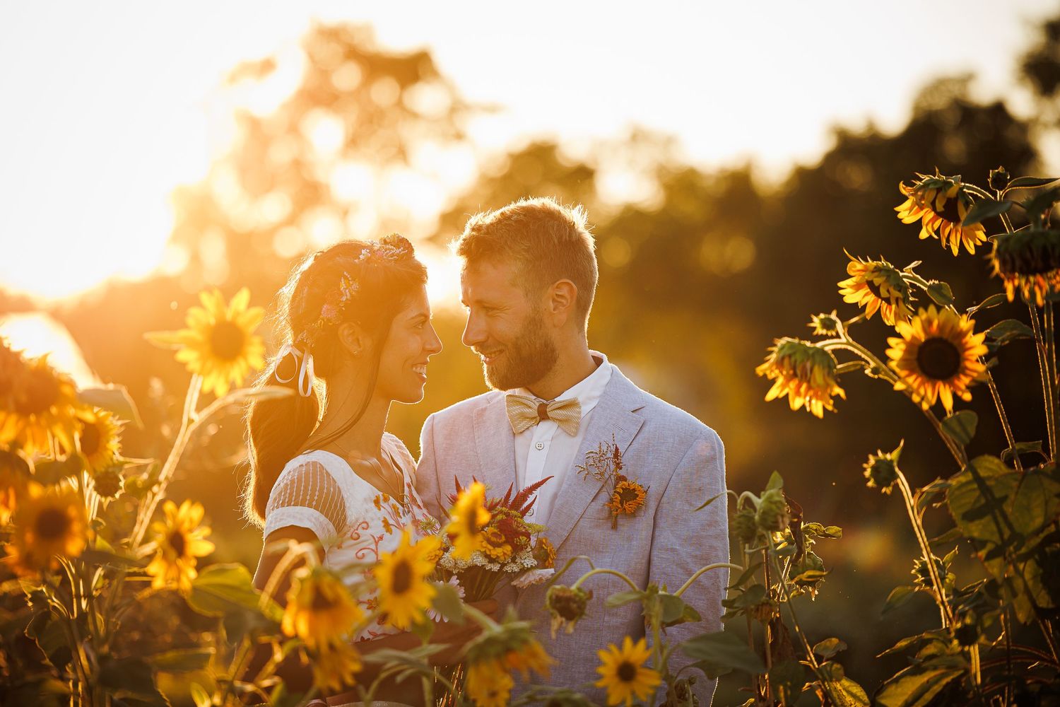 A romantic sunset moment in a sunflower field with golden light filtering through the flowers.