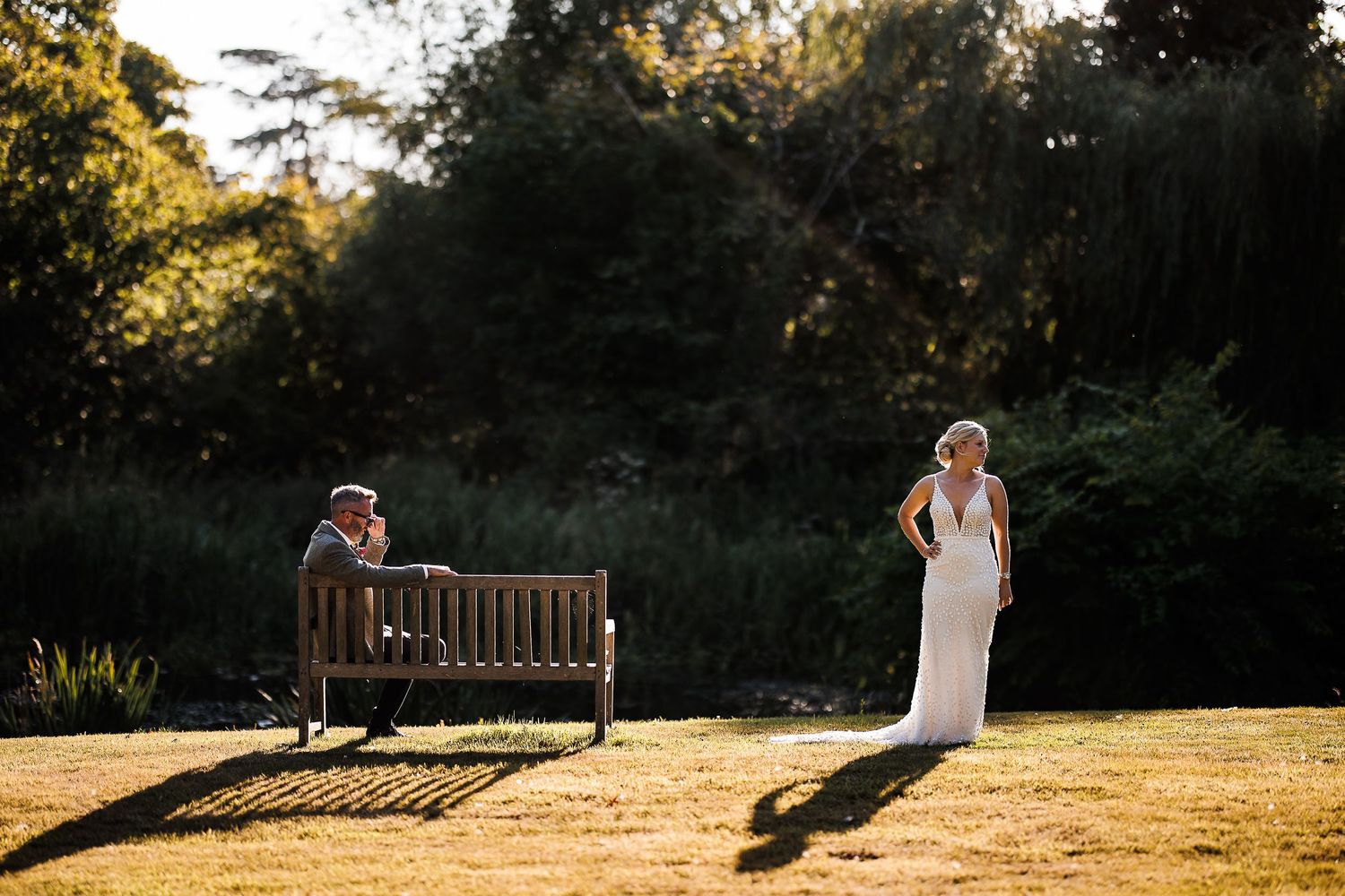 A couple shares a romantic moment at sunset on the grounds of their outdoor wedding venue.