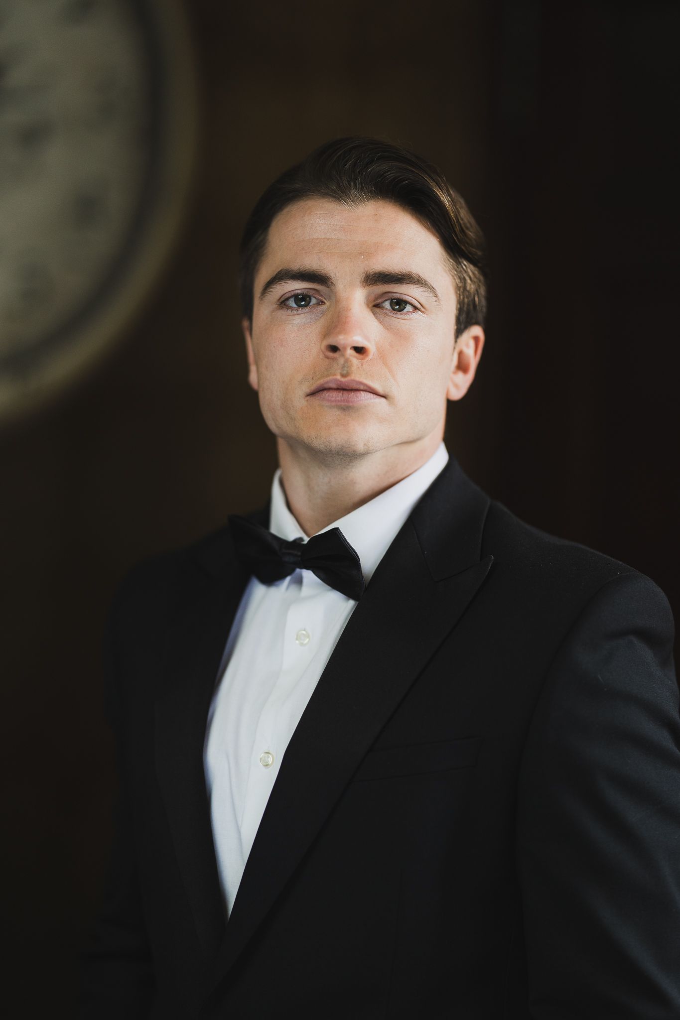 Classic formal portrait of a man in black tuxedo and bow tie.