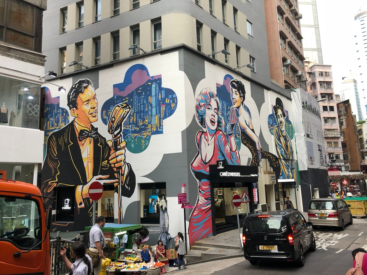 Belebte Strassenecke mit Wandmalerei und Verkehr Hong Kong