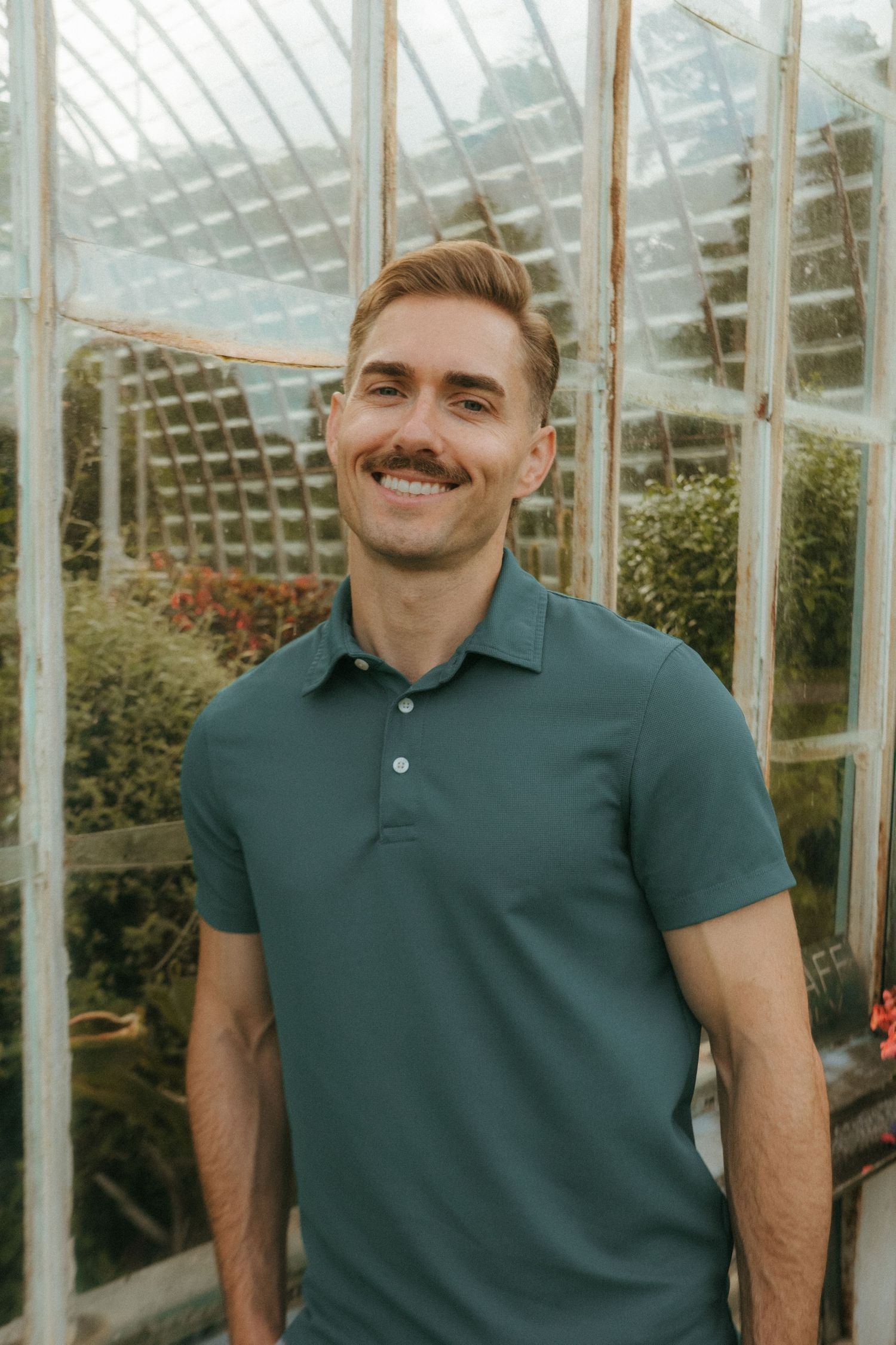 Portrait of young man in Killarney National Park, he has short blonde hair and a mustache.