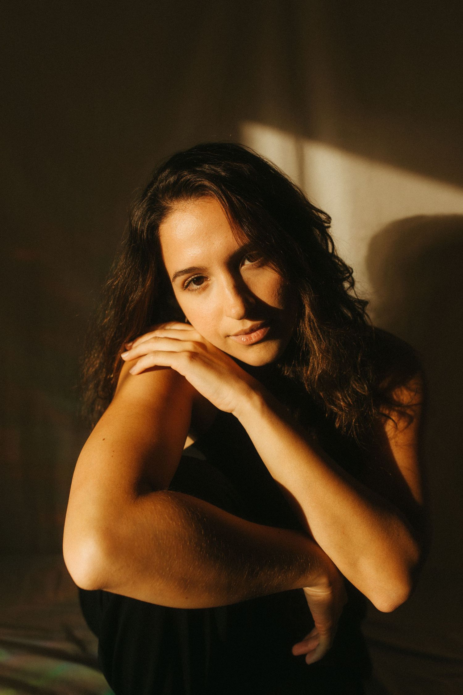 photograph of a dark haired model in a studio setting, soft contrast.