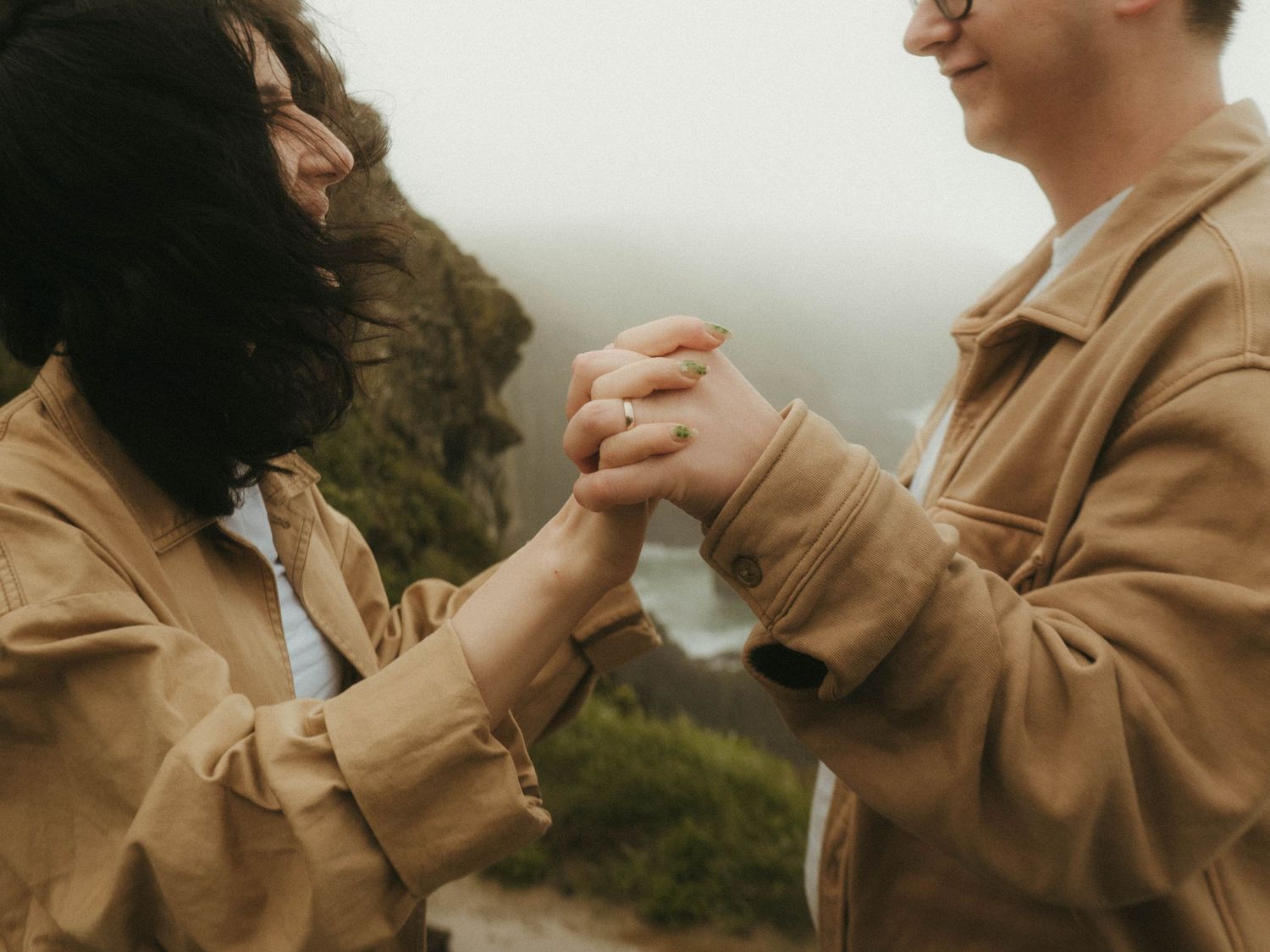 Photograph of a couple holding hands and looking at each other in front of Old Head of Kinsale