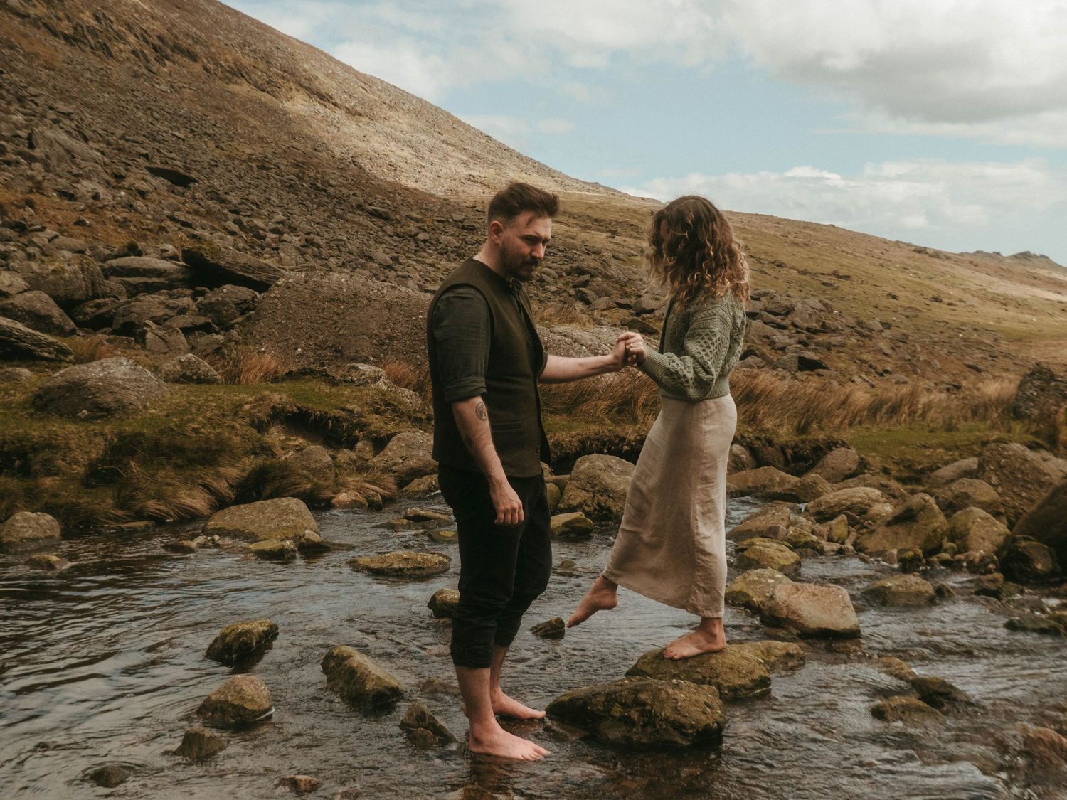 Photograph of couple standing in a stream at Mahon Falls in Waterford.