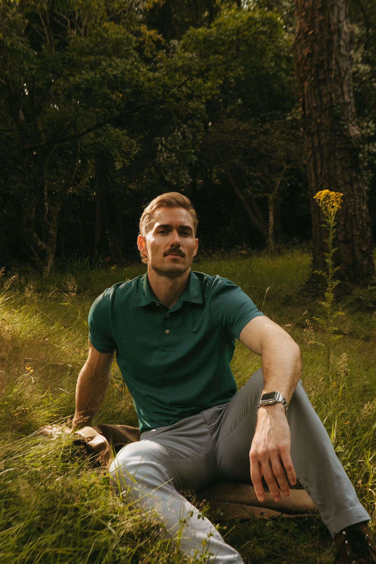 Portrait of young man in Killarney National Park, he has short blonde hair and a mustache.