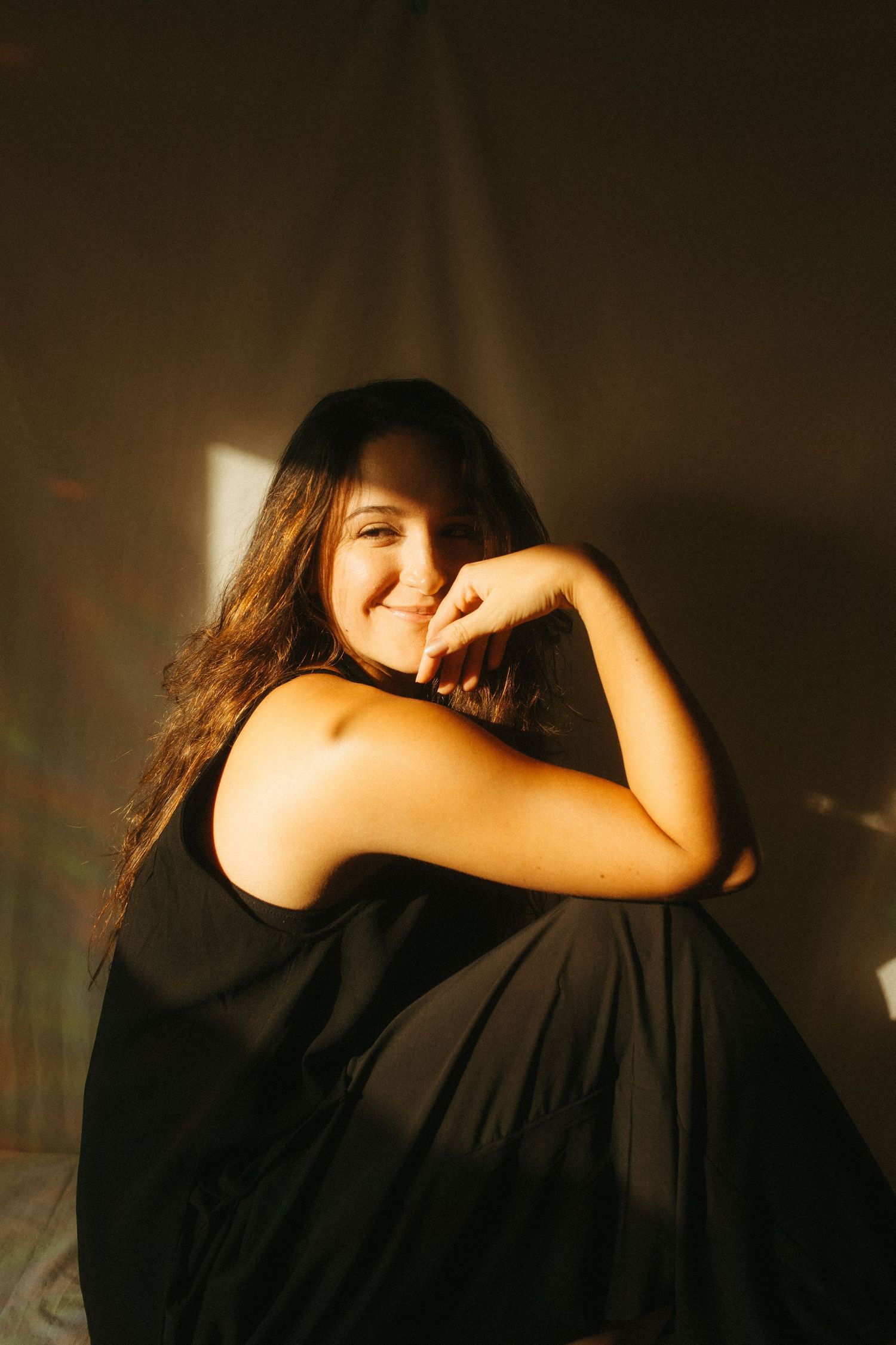 photograph of a dark haired model in a studio setting, soft contrast.