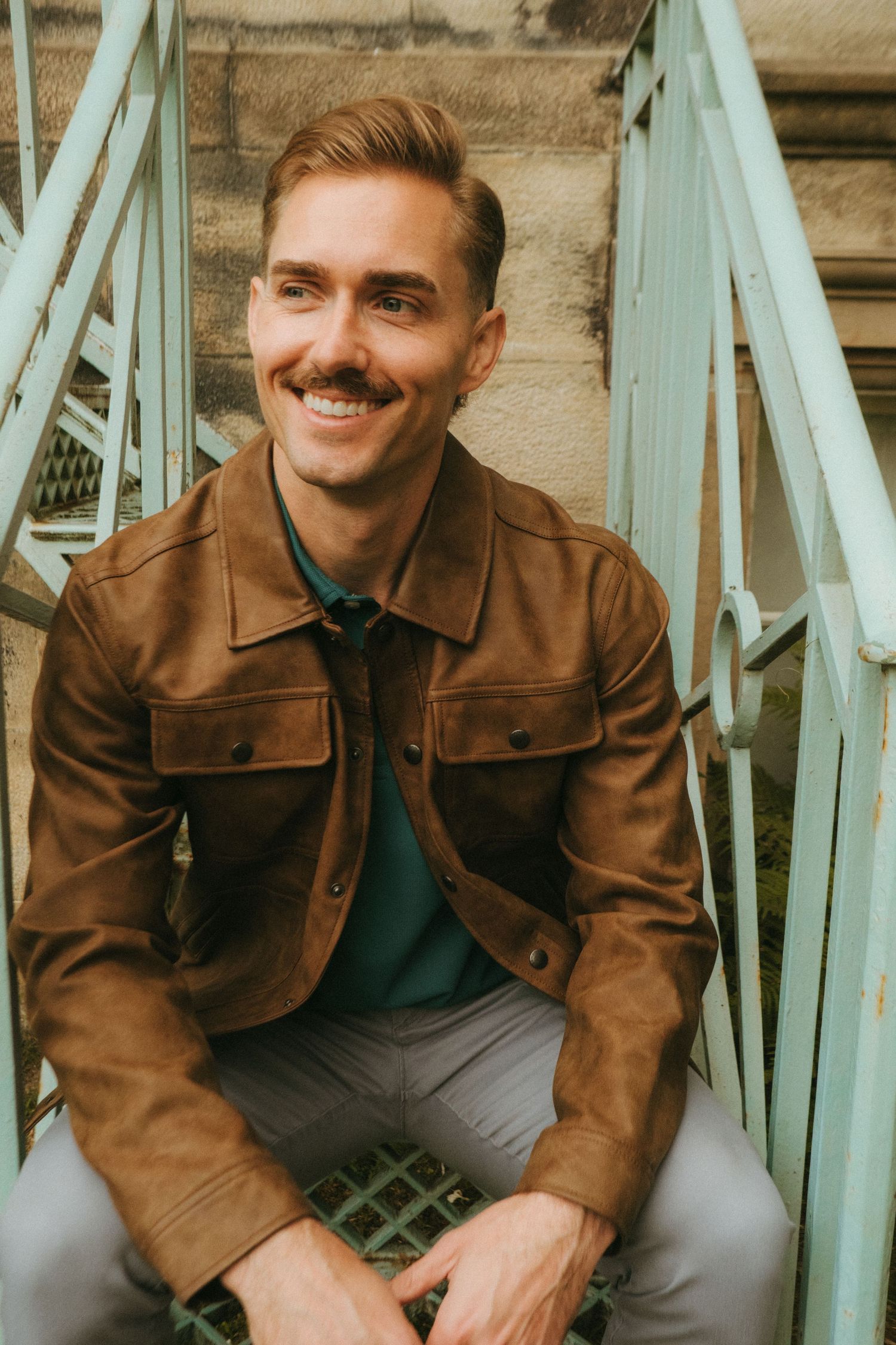 Portrait of young man in Killarney National Park, he has short blonde hair and a mustache.