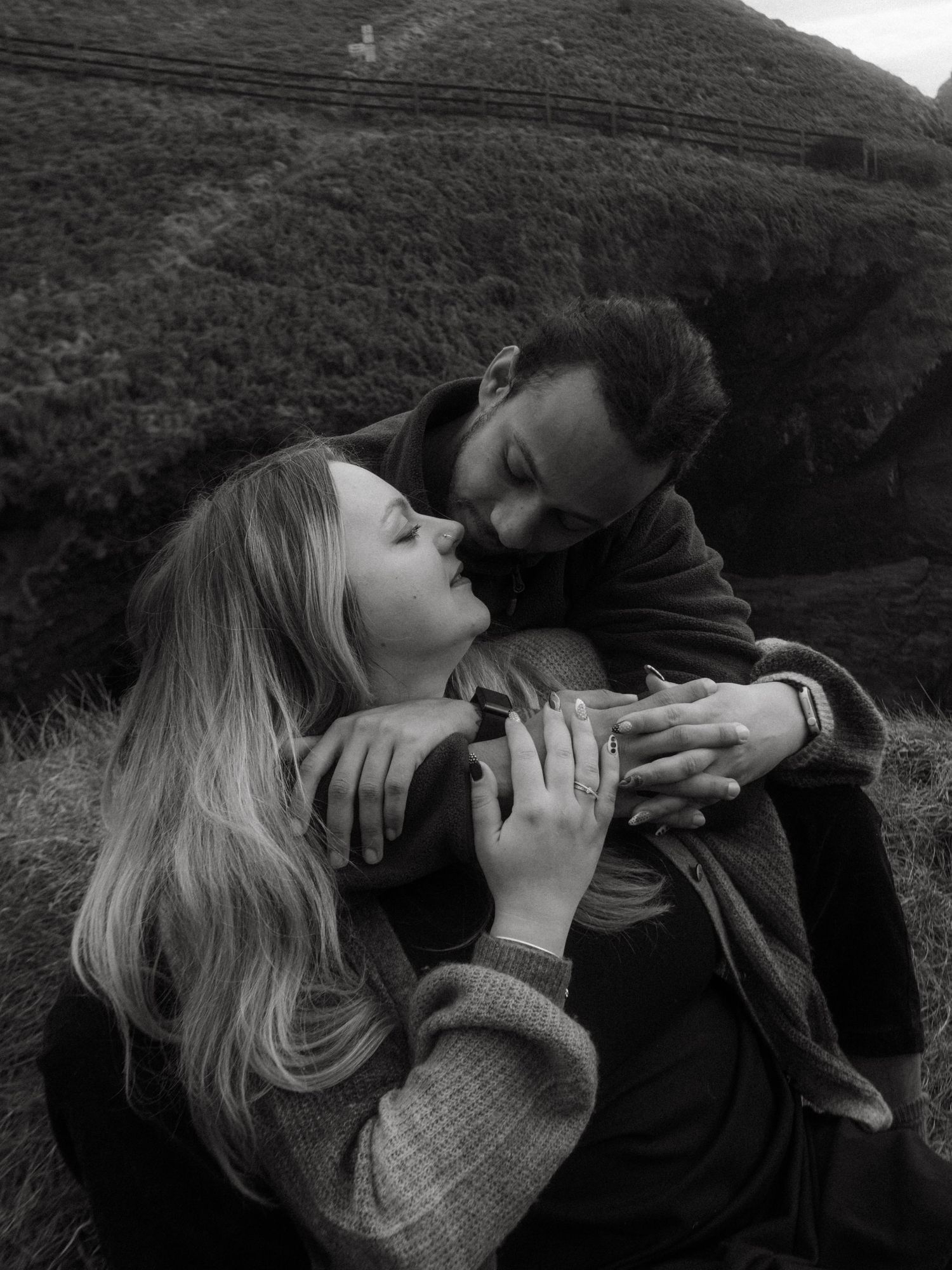 Photograph of couple posing at Nohoval Cove in Cork, Ireland. Soft contrast, warm colors.