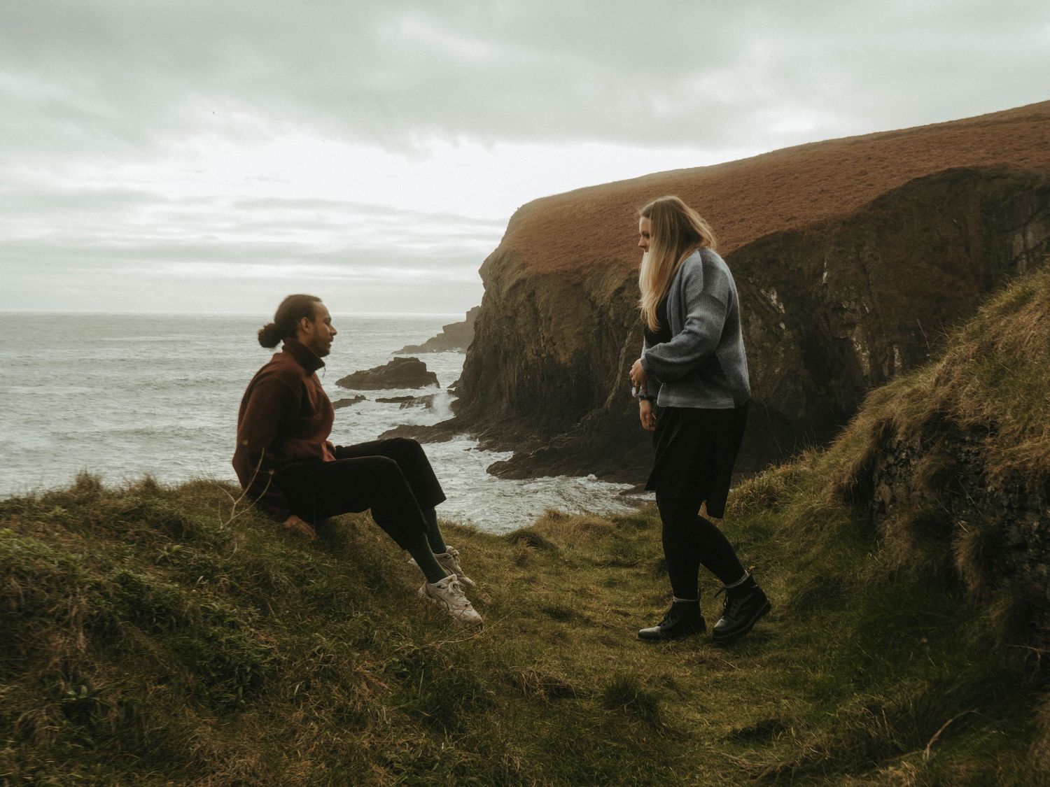 Photograph of couple posing at Nohoval Cove in Cork, Ireland. Soft contrast, warm colors.