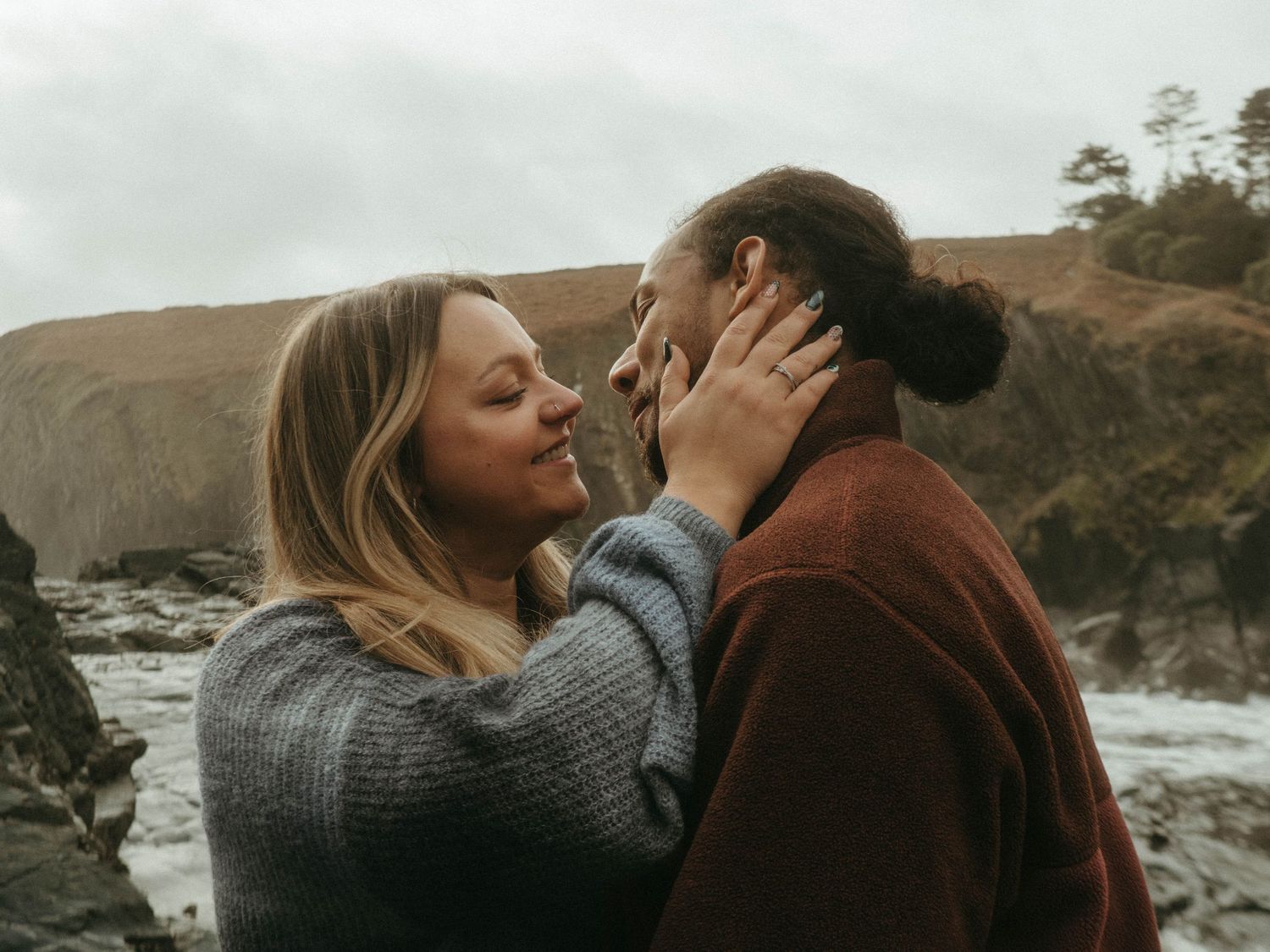 Photograph of couple posing at Nohoval Cove in Cork, Ireland. Soft contrast, warm colors.
