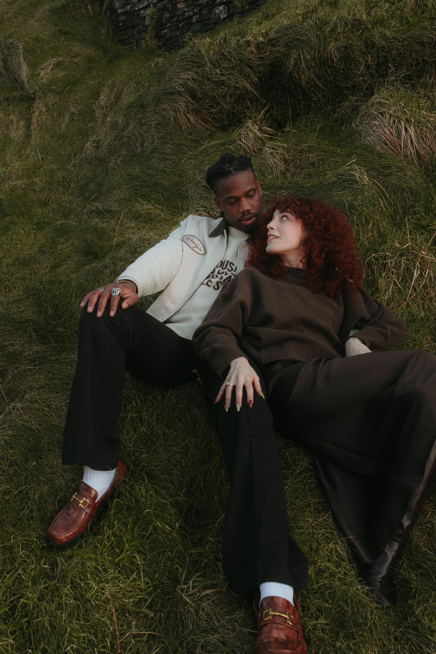 Photograph of couple laying in tall grass