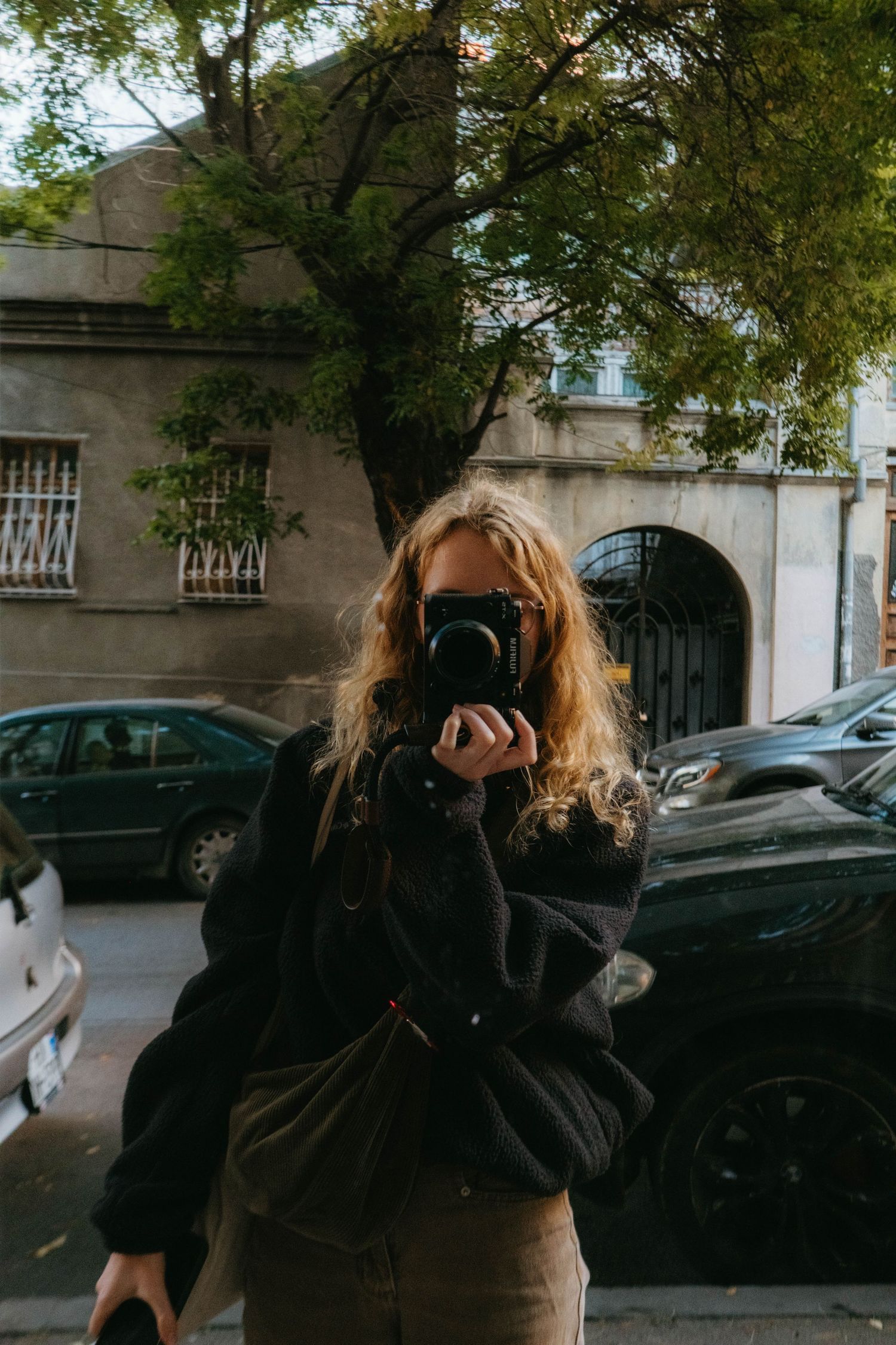 Self portrait of the photographer made in a mirror on the streets of Tbilisi, you can see her holding her camera
