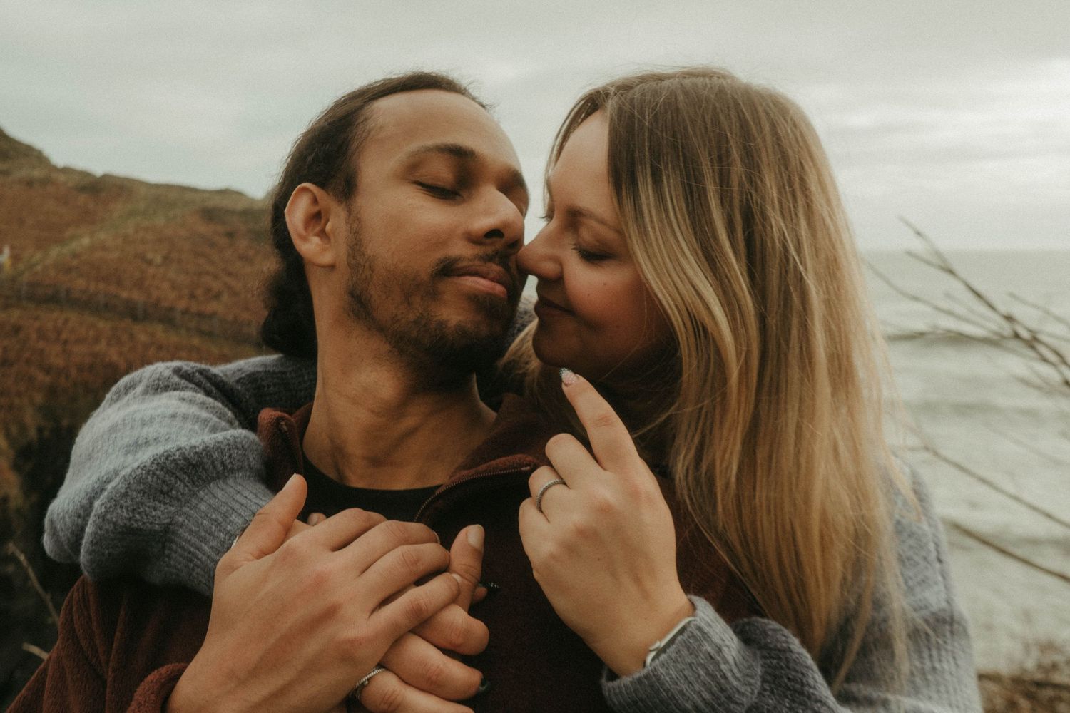 Photograph of couple posing at Nohoval Cove in Cork, Ireland. Soft contrast, warm colors.