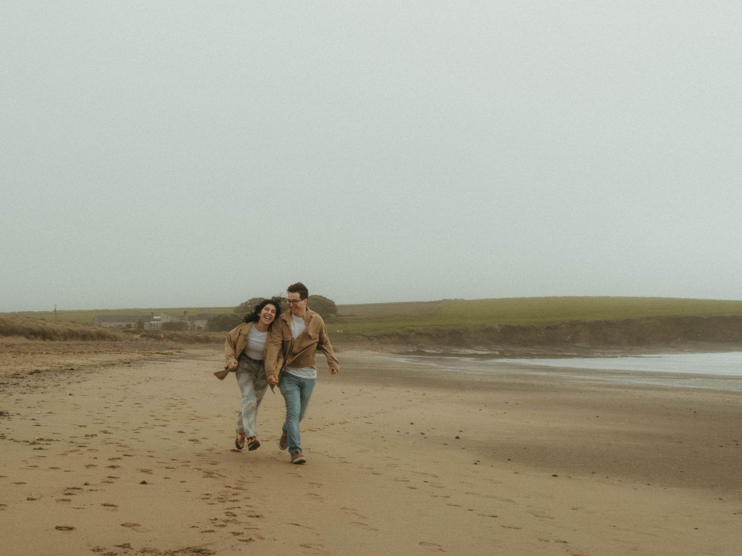 photograph of couple running at a beach