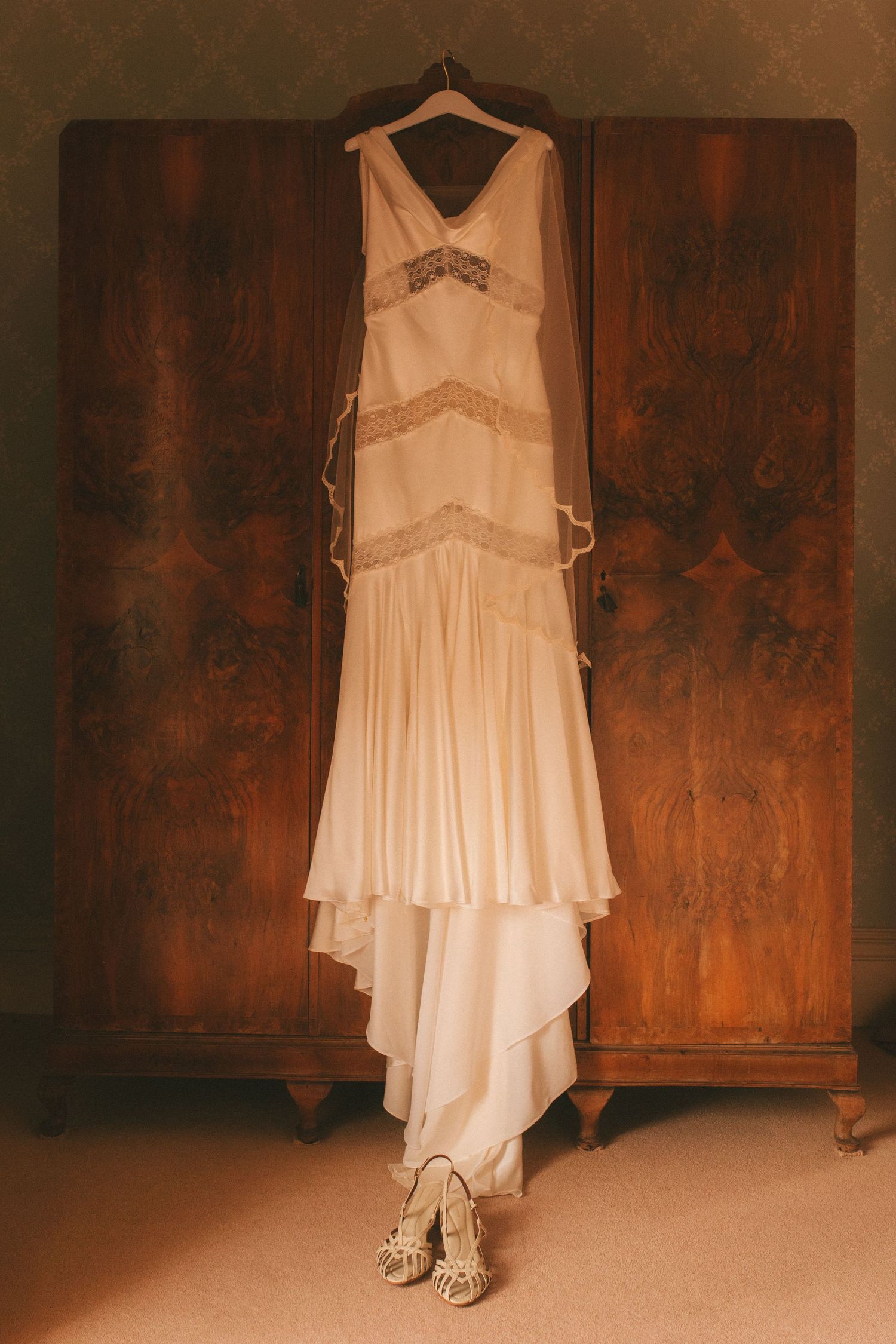 Detail shot of wedding dress hanging on a vintage closet.