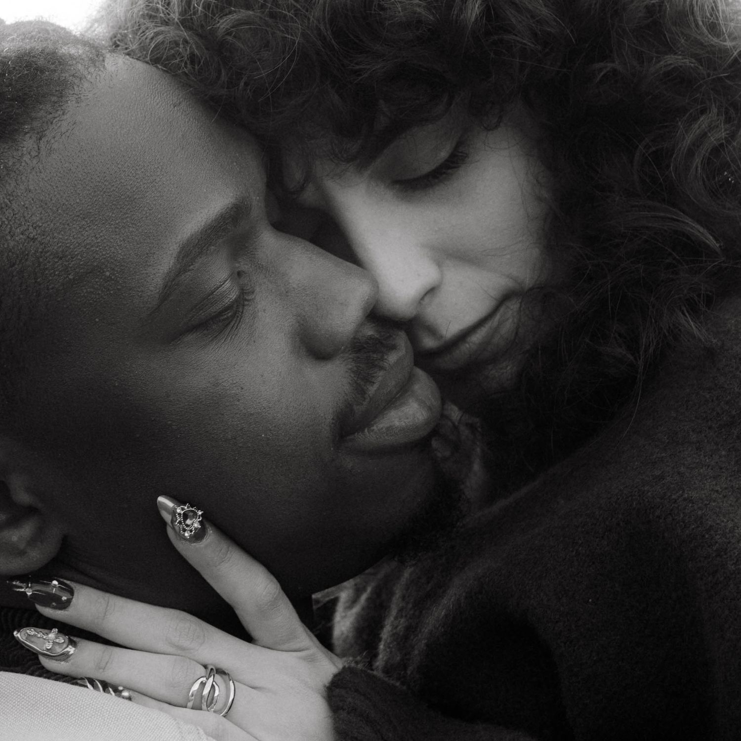 Black and white photograph of biracial couple, closeup of their noses touching