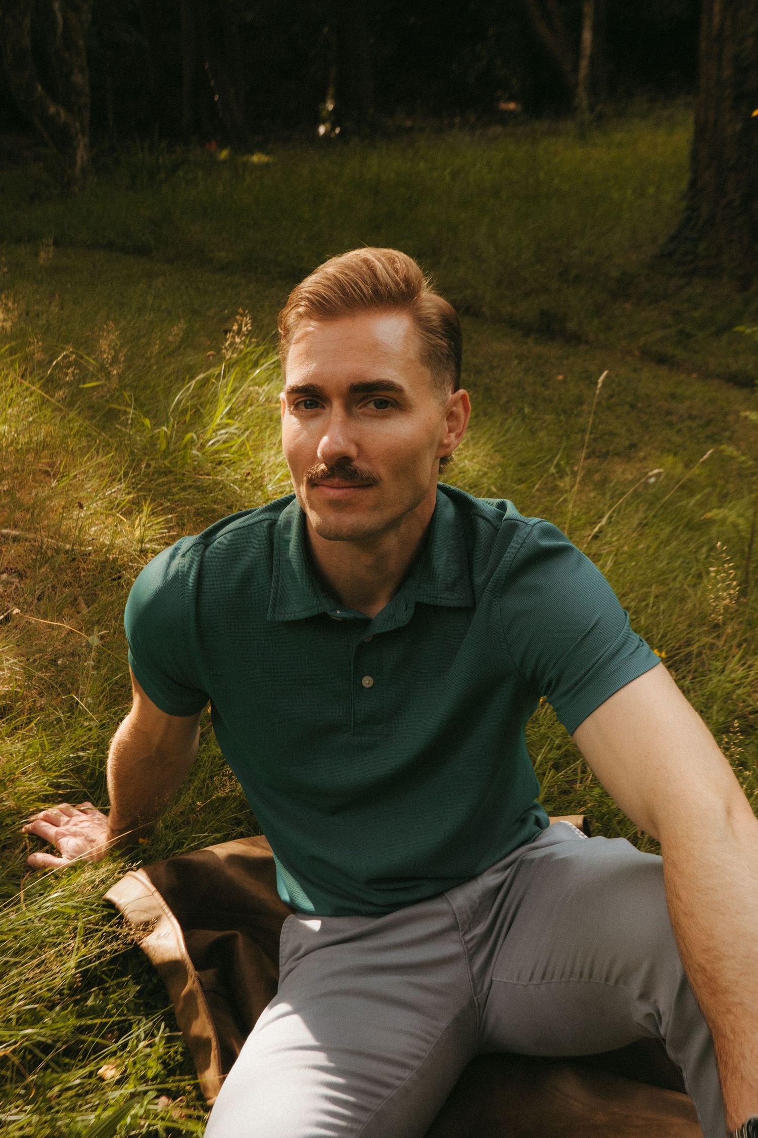 Portrait of young man in Killarney National Park, he has short blonde hair and a mustache.