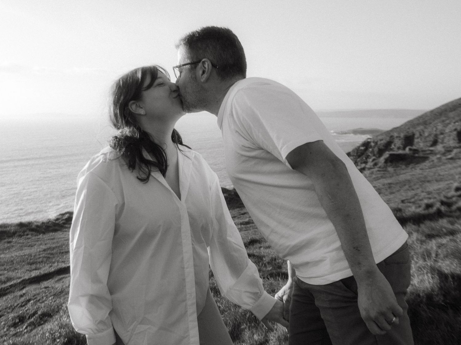 Black and white photograph of a couple at Old Head of Kinsale kissing