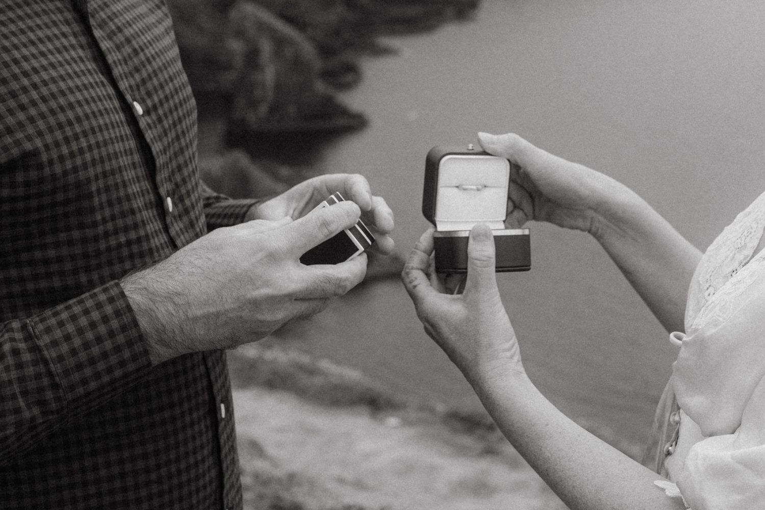 Black and white photograph of a couple during their elopement exchanging rings at the Old Head of Kinsale.