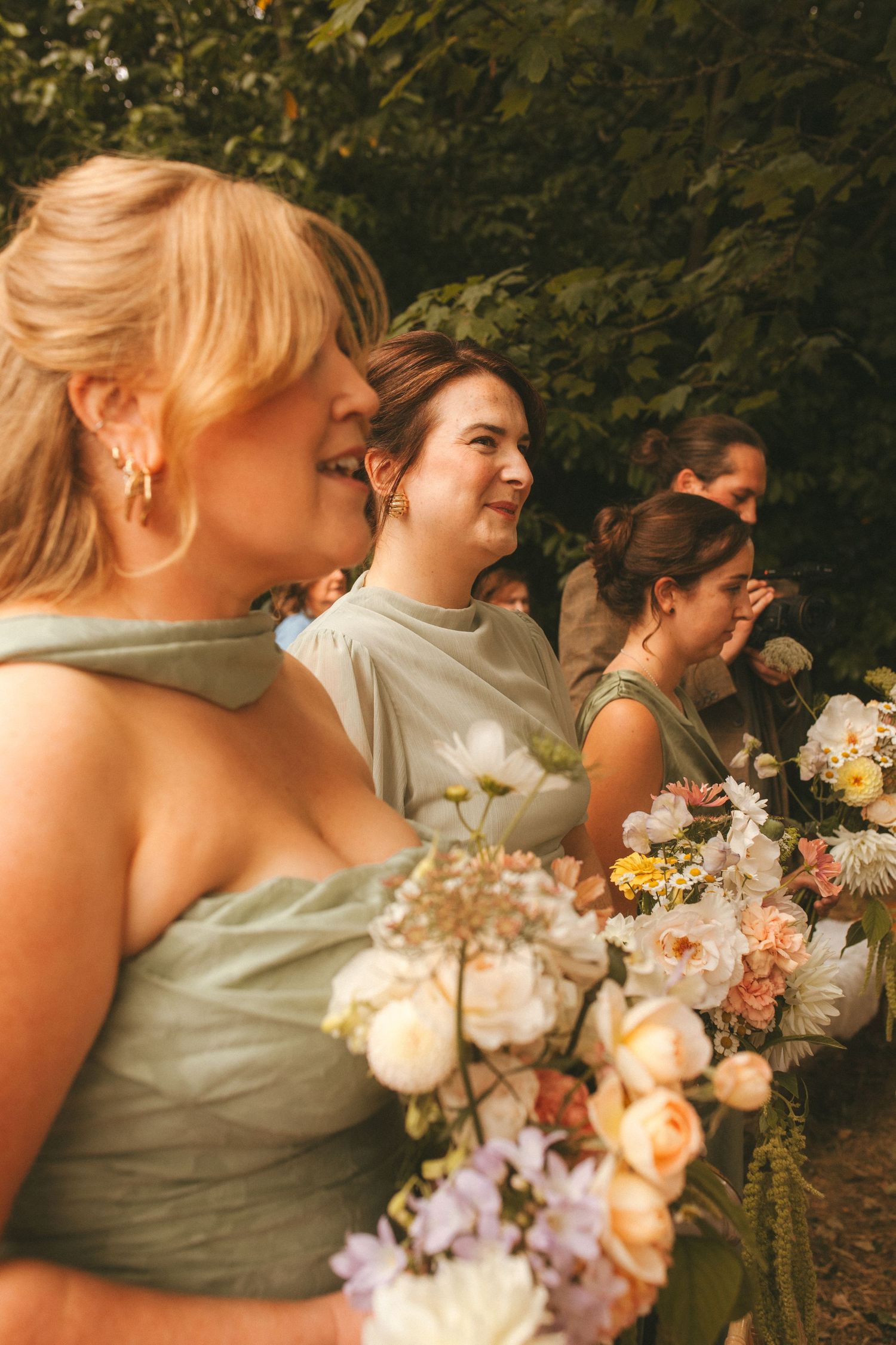 Photograph of bridesmaids during the ceremony, they are wearing light green dresses