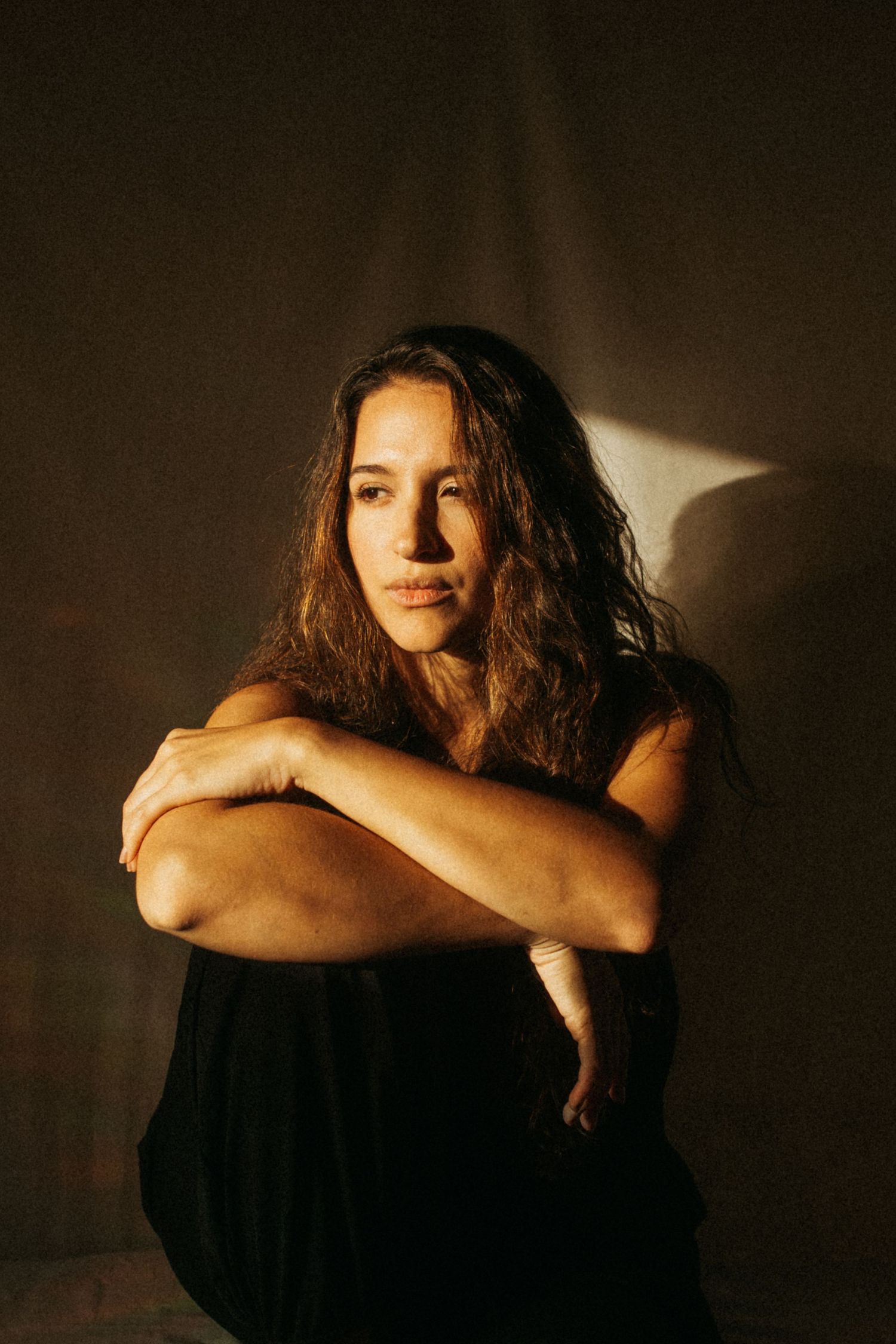 photograph of a dark haired model in a studio setting, soft contrast.