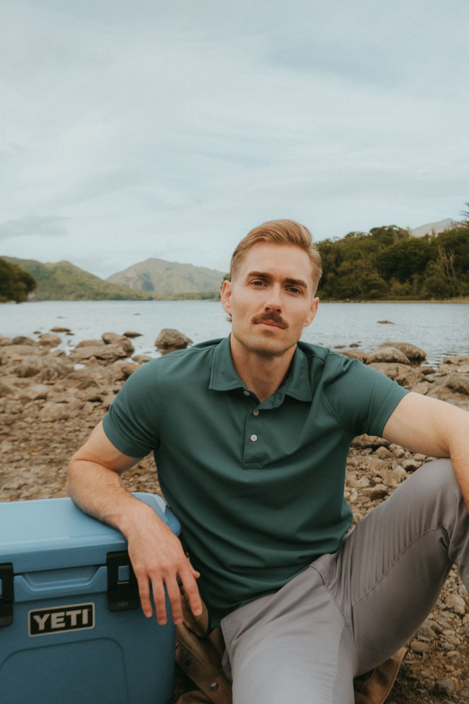 Portrait of young man in Killarney National Park, he has short blonde hair and a mustache.
