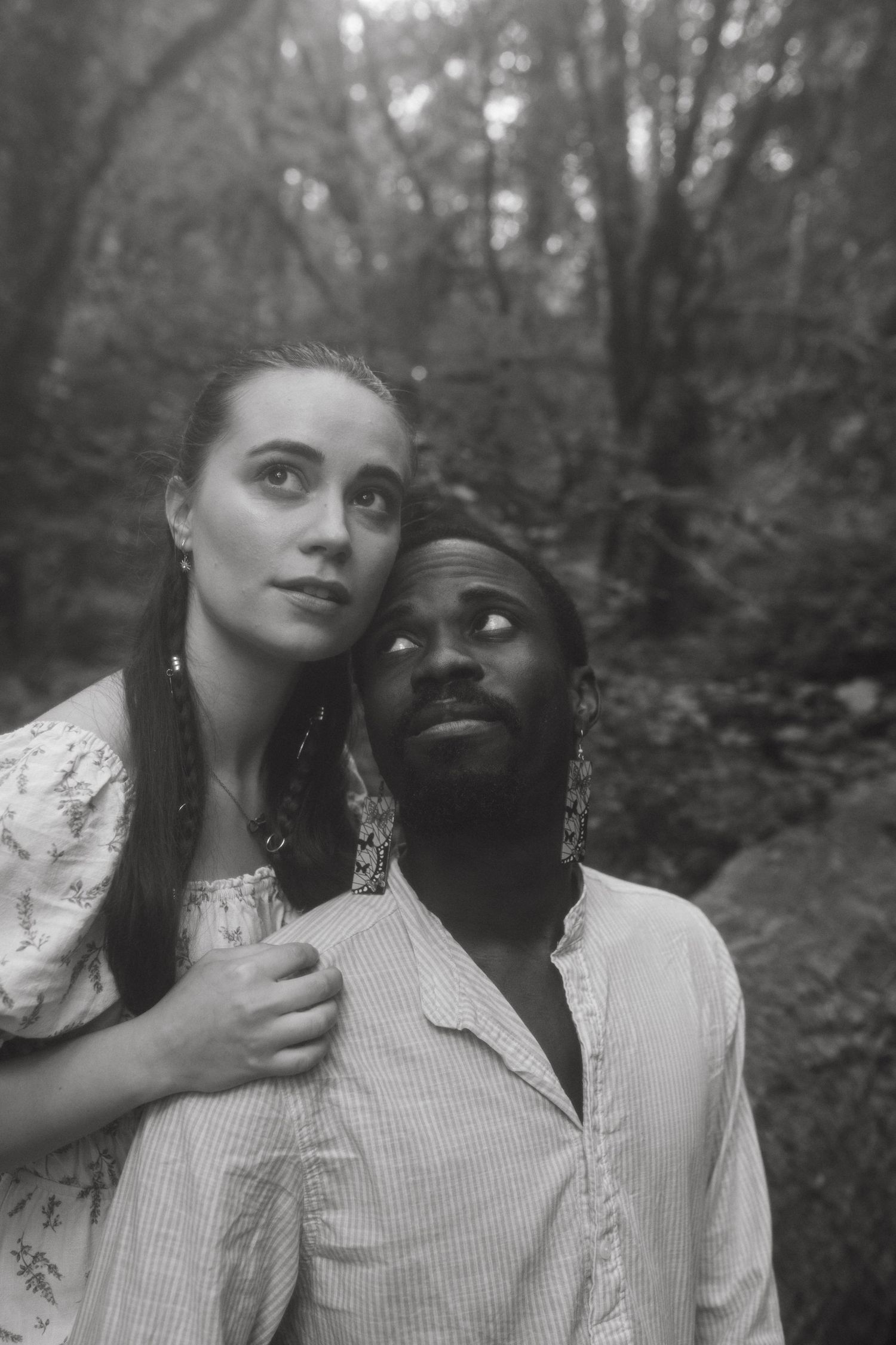 Black and white photograph of couple posing in a forest