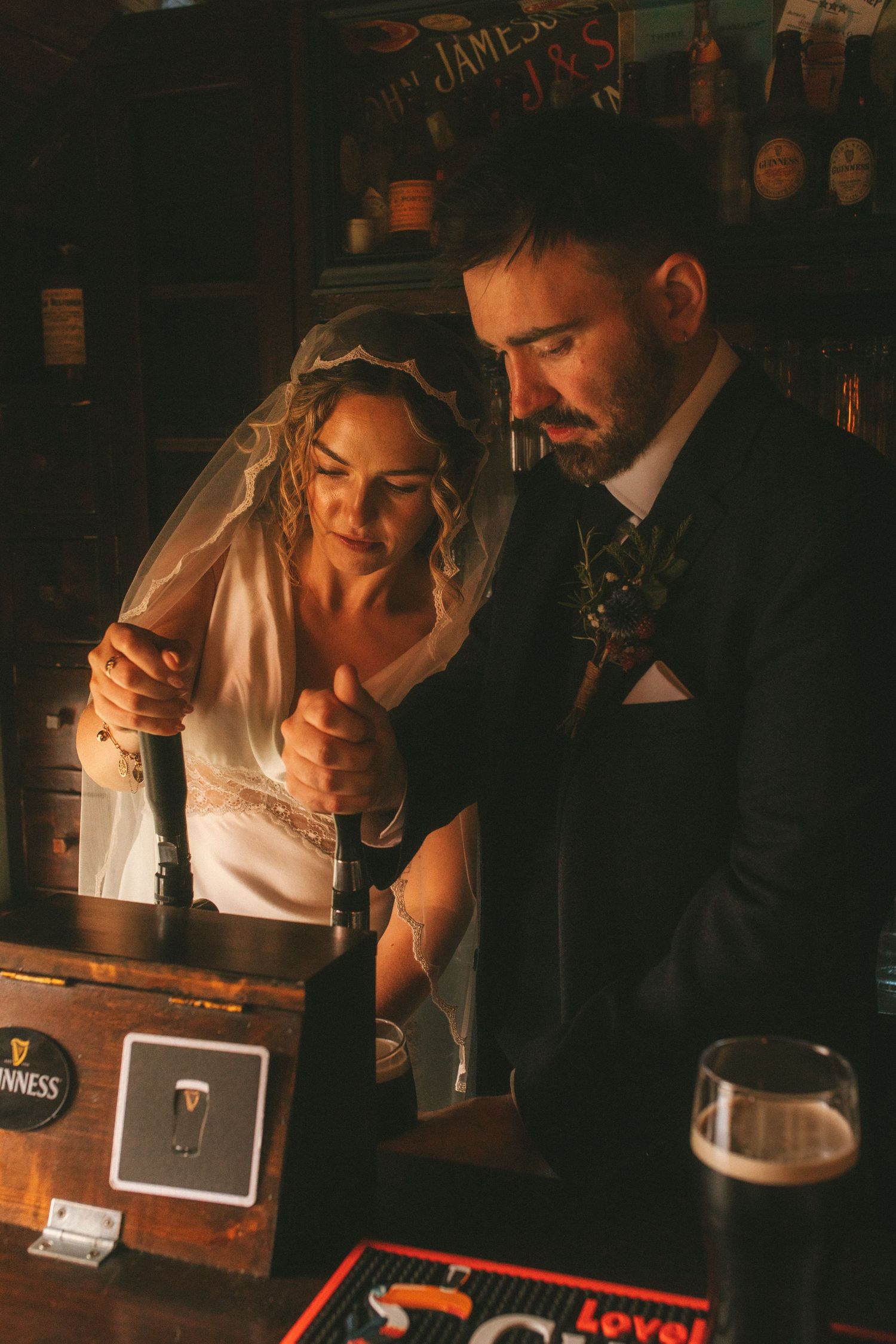 Photograph of bride and groom tapping their own Guinness
