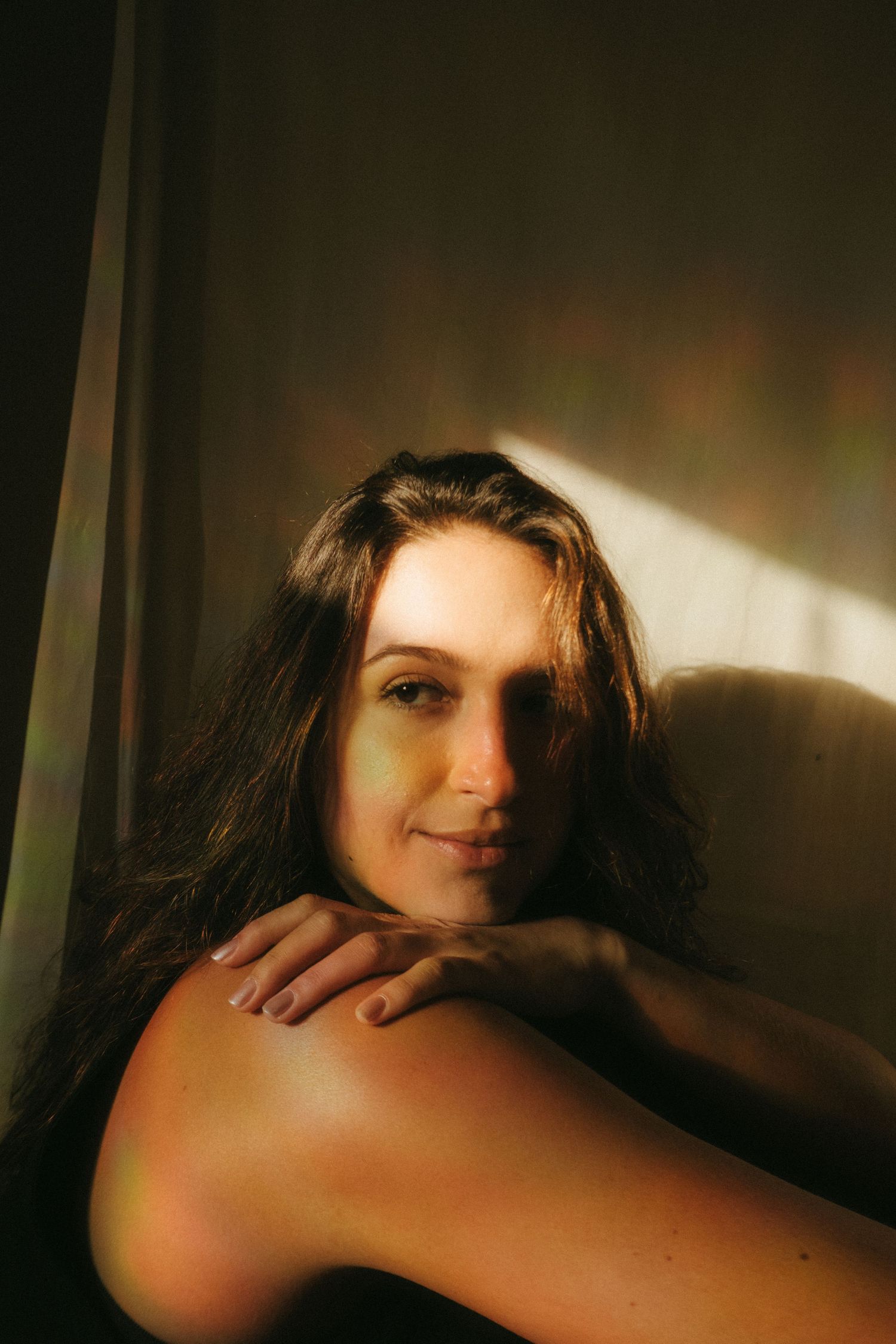 photograph of a dark haired model in a studio setting, soft contrast.