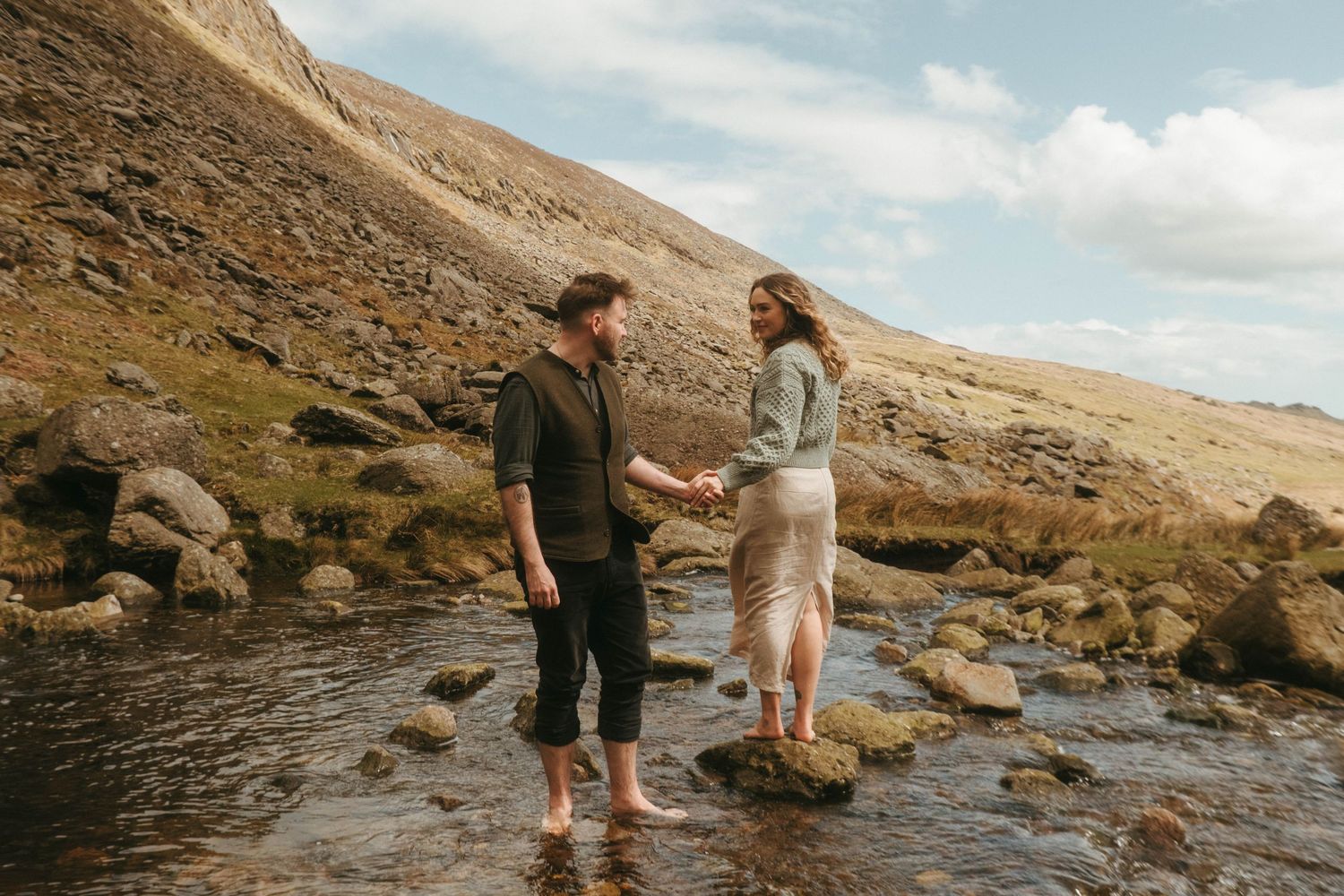 Photograph of couple standing in a stream at Mahon Falls in Waterford.