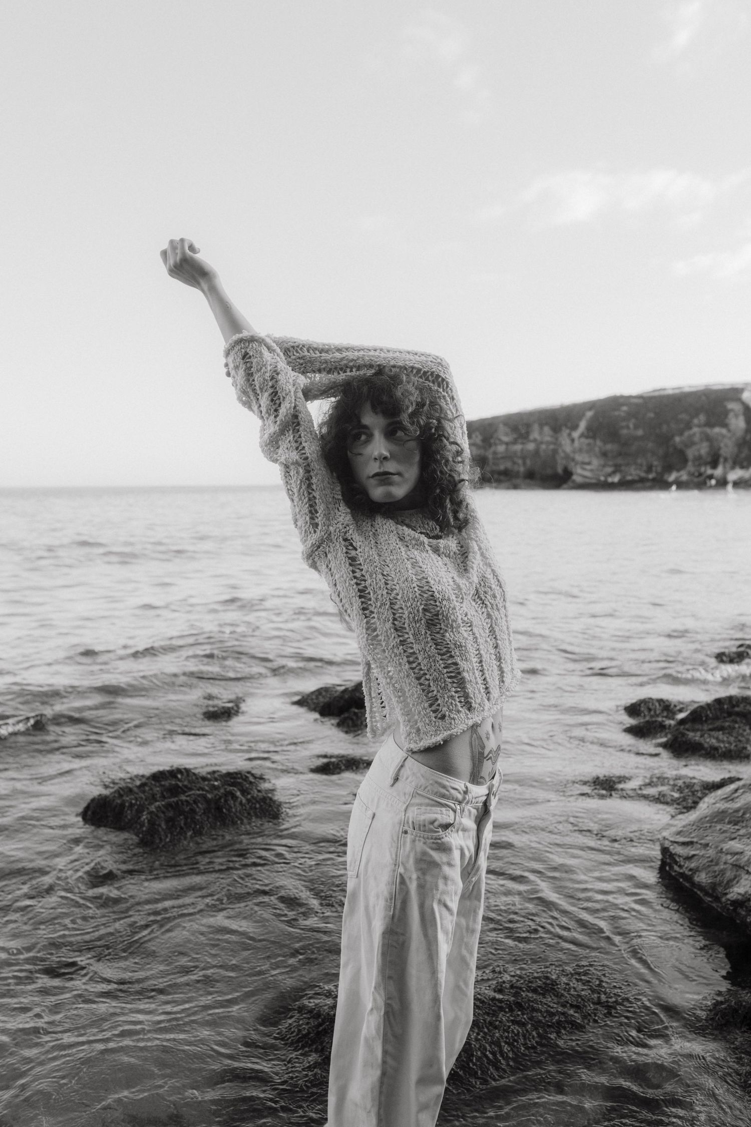 Black and white Photograph of a model in front of a rocky beach at Rocky Bay in Cork.