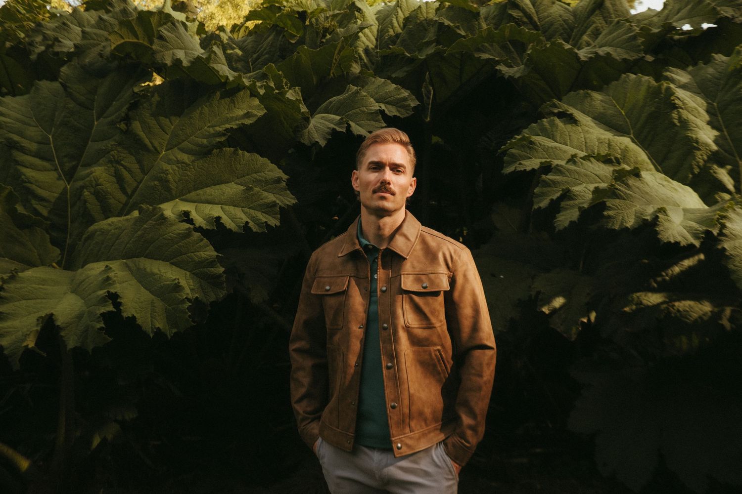 Portrait of young man in Killarney National Park, he has short blonde hair and a mustache.