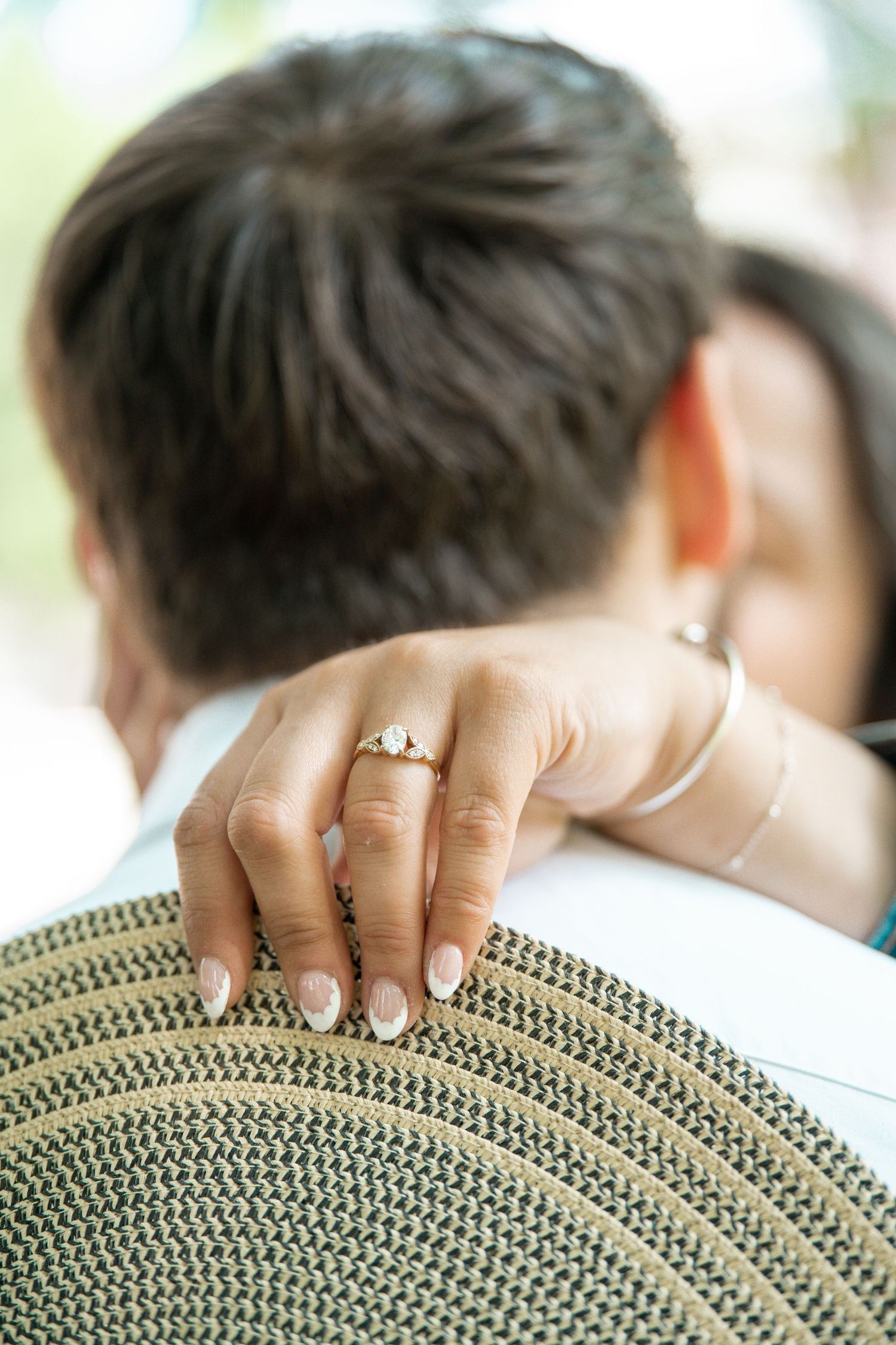 Engagement photo featuring an up close ring shot. The bride's hand is wrapped around her grooms neck during this session in Worcester, MA
