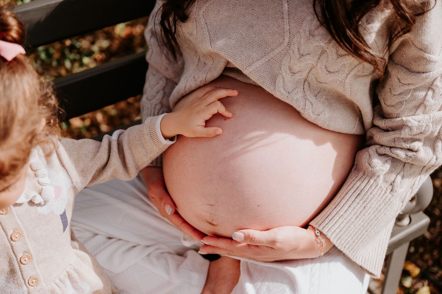 Adelaide newborn photographer capturing a big sister's hand on beautiful bump